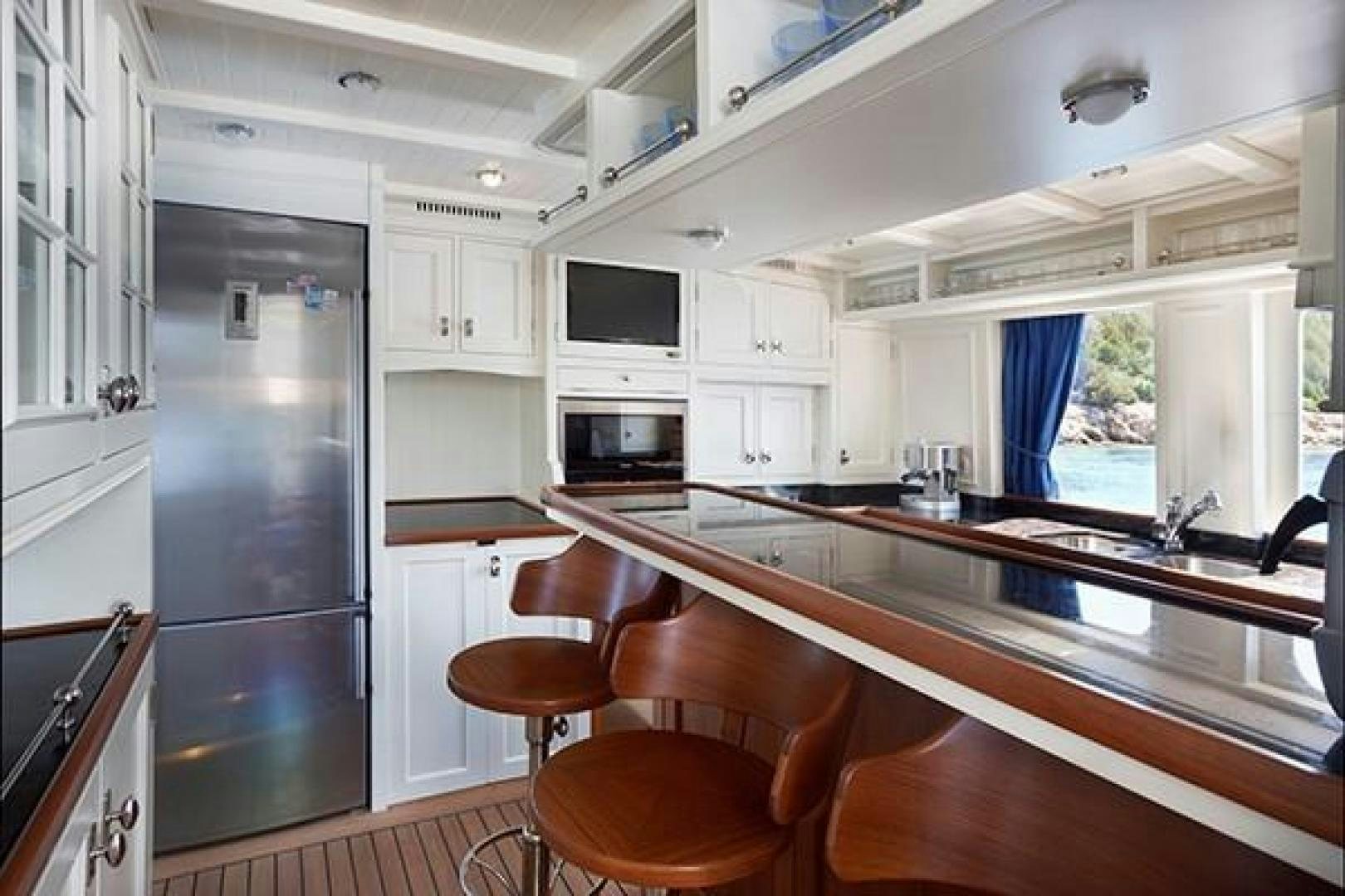 a kitchen with a black refrigerator aboard DARWIN Yacht for Sale