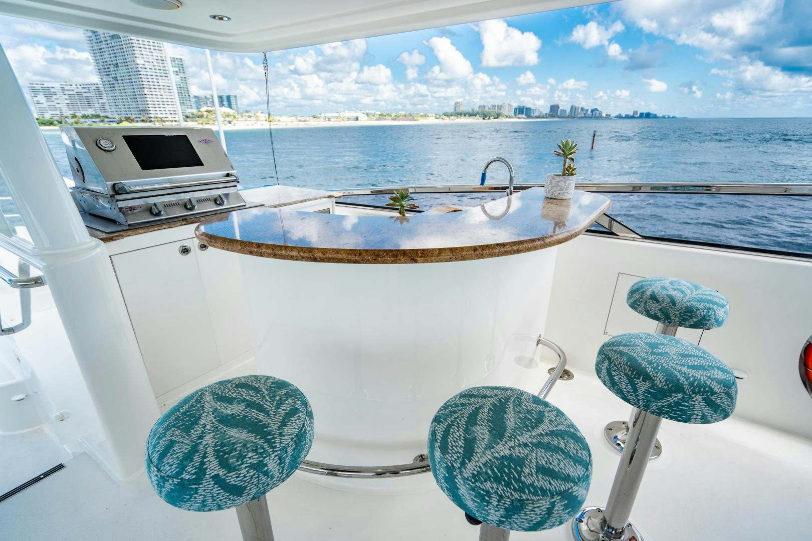 a table with blue chairs and a laptop on it aboard WILD KINGDOM Yacht for Sale