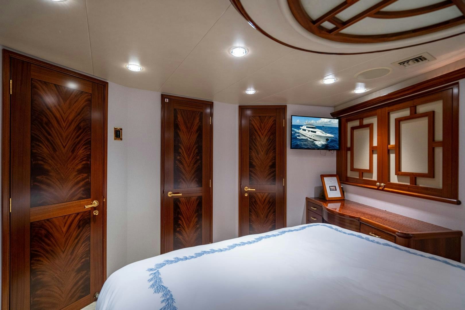 a bedroom with a bed and a wood door aboard WILD KINGDOM Yacht for Sale