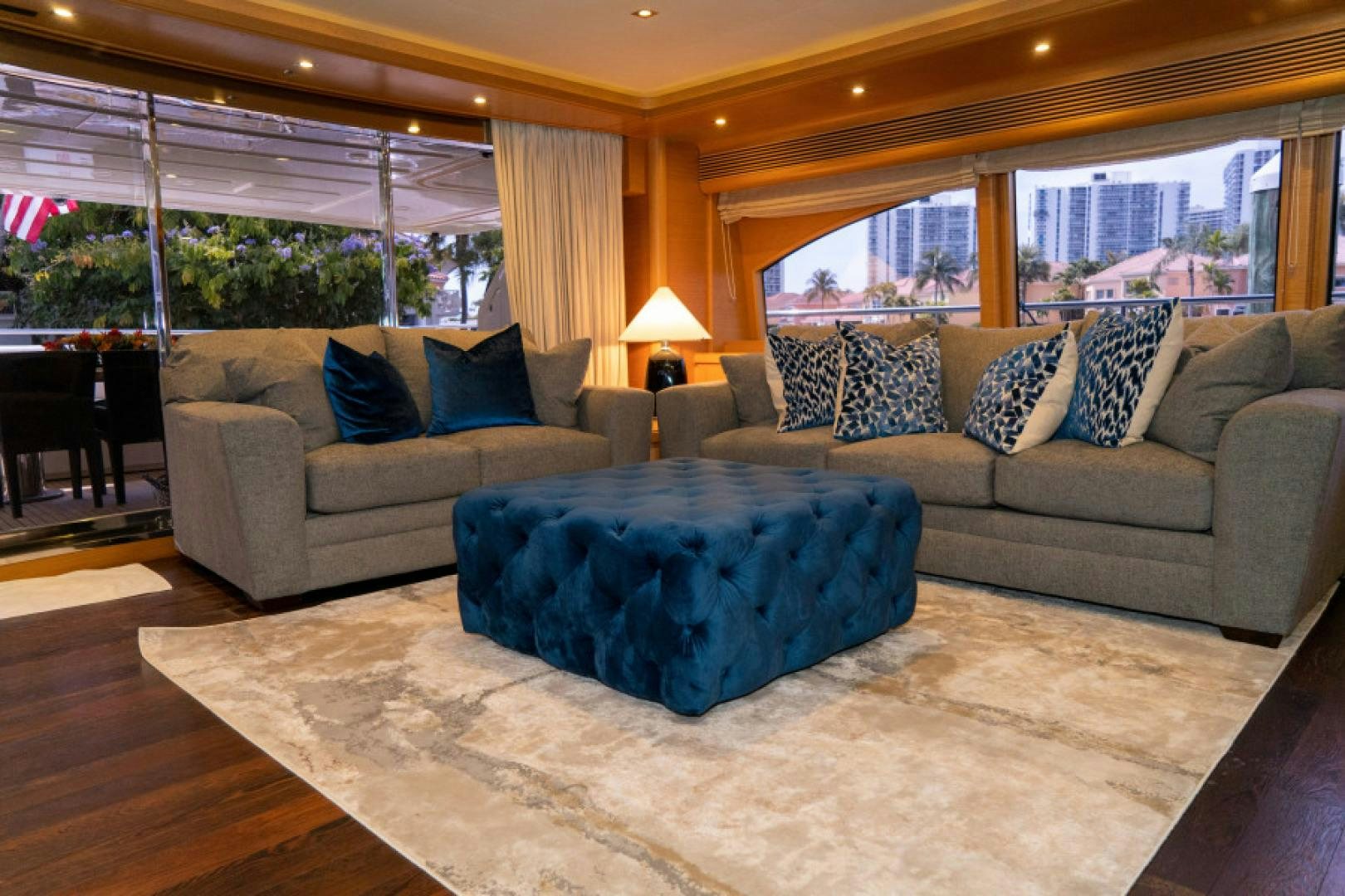 a living room with a large blue couch and a large blue round table aboard ADAR Yacht for Sale