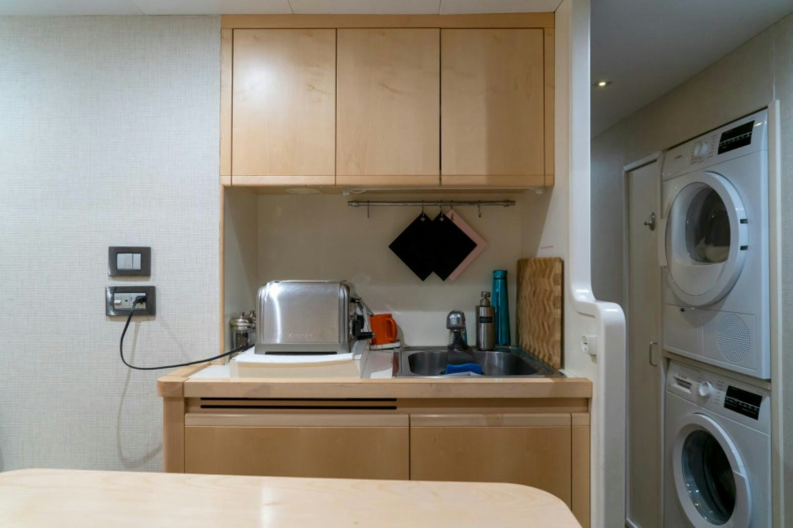 a small kitchen with a washing machine aboard ADAR Yacht for Sale