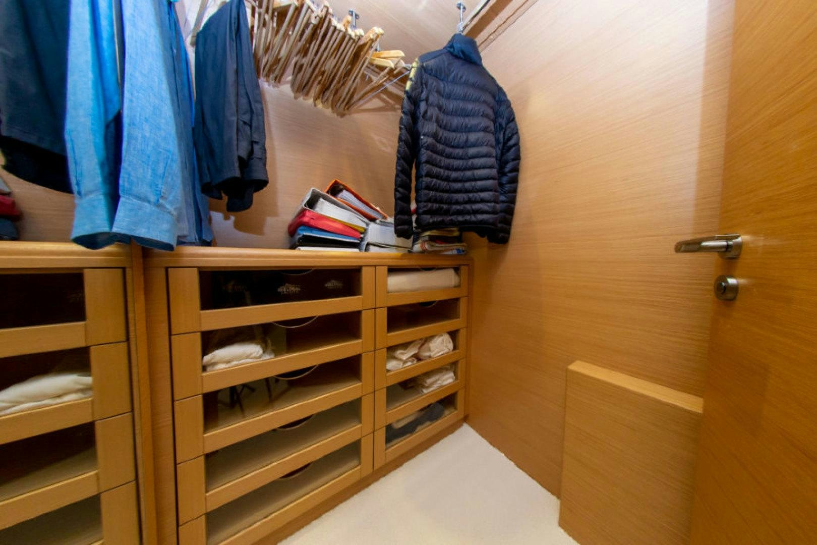 a closet with clothes on the wall aboard ADAR Yacht for Sale