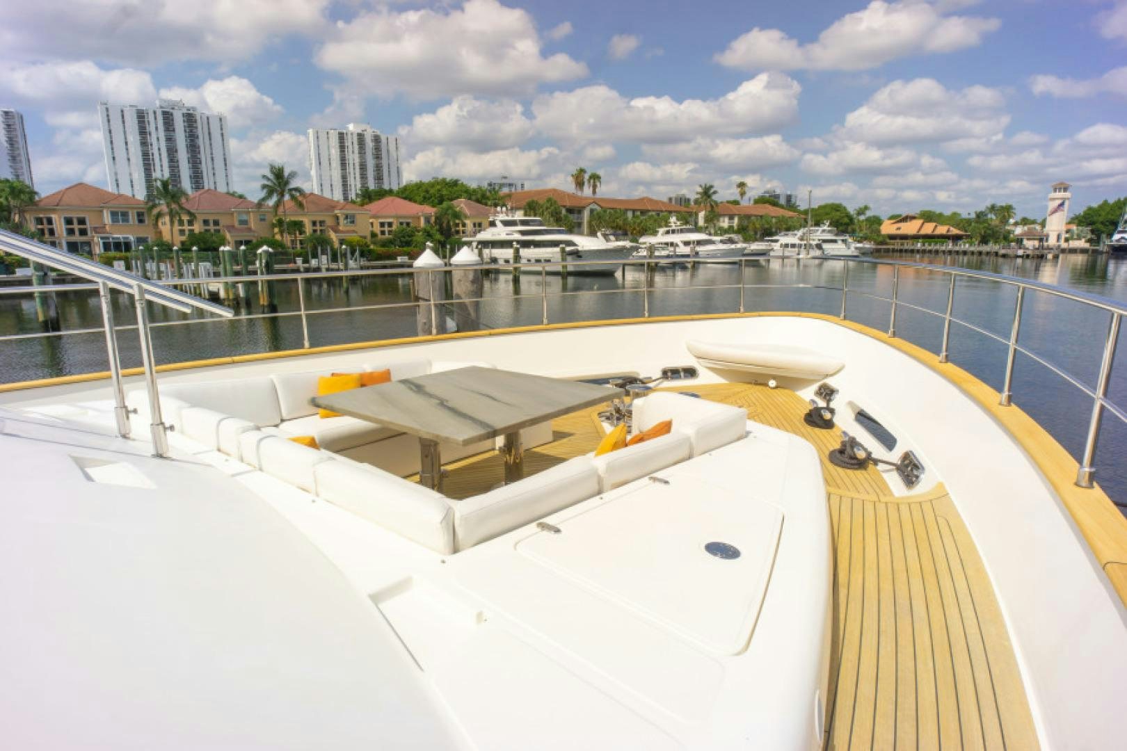a large pool with a deck and a city in the background aboard ADAR Yacht for Sale