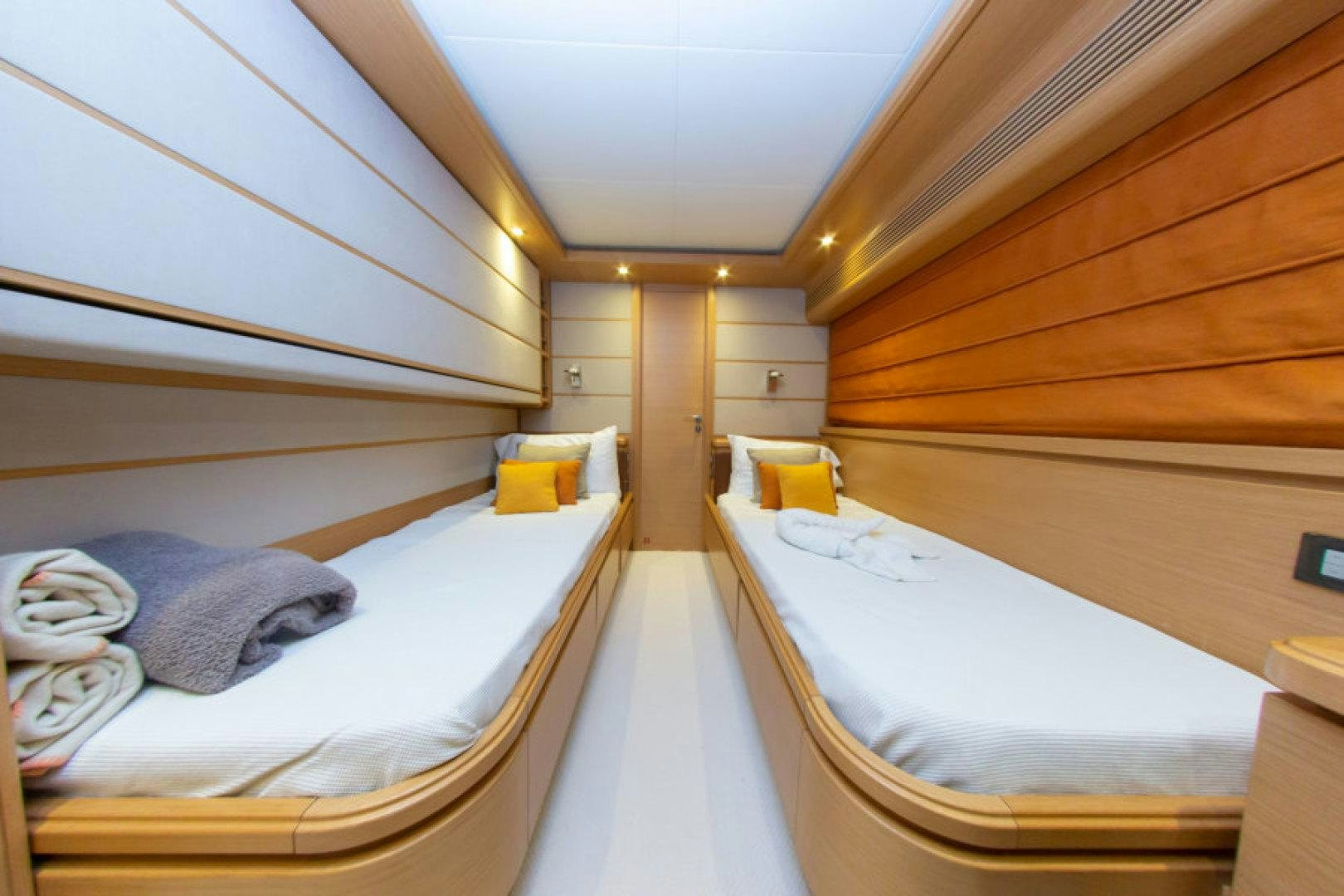 a room with beds and a wood wall aboard ADAR Yacht for Sale