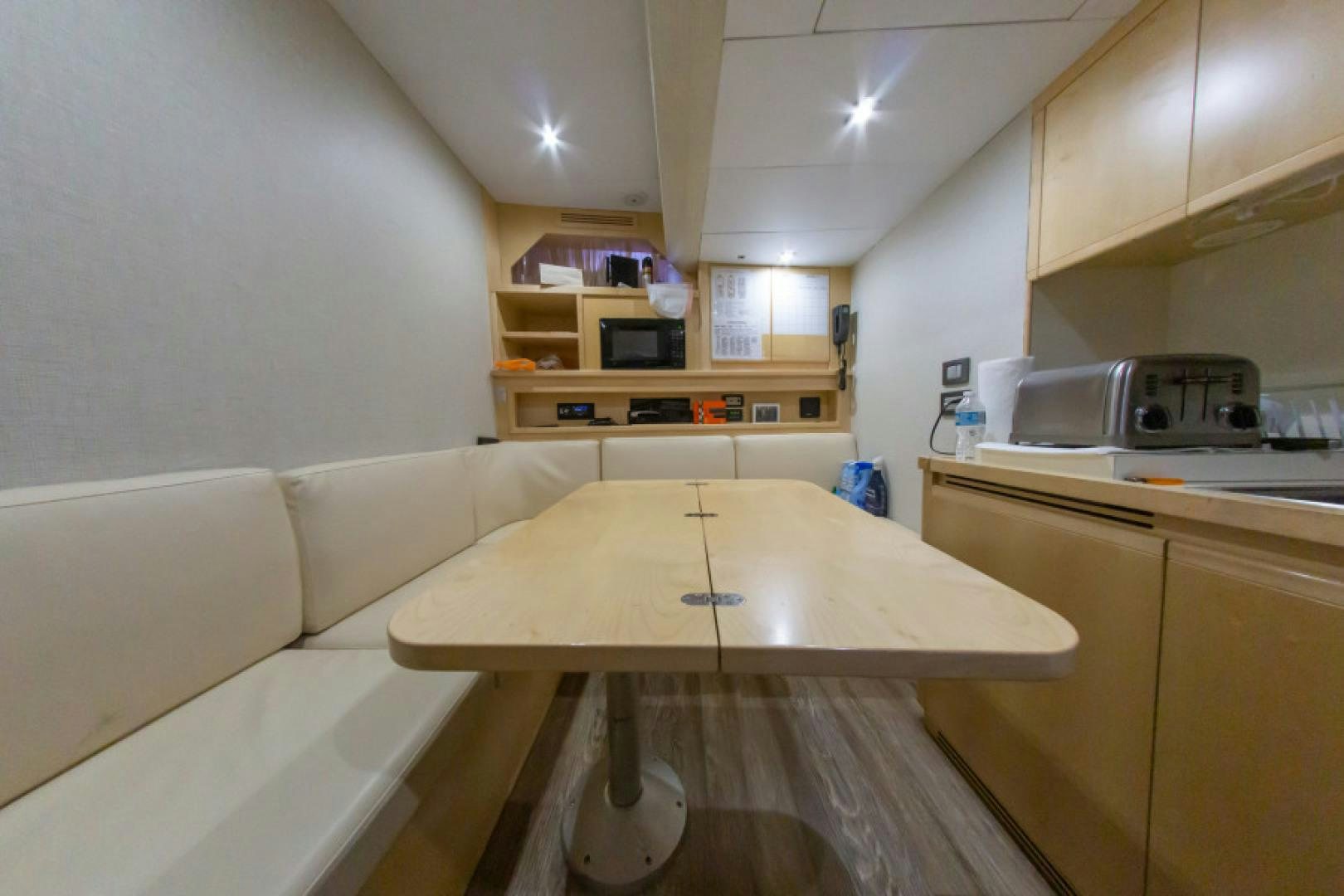 a kitchen with a table and a couch aboard ADAR Yacht for Sale