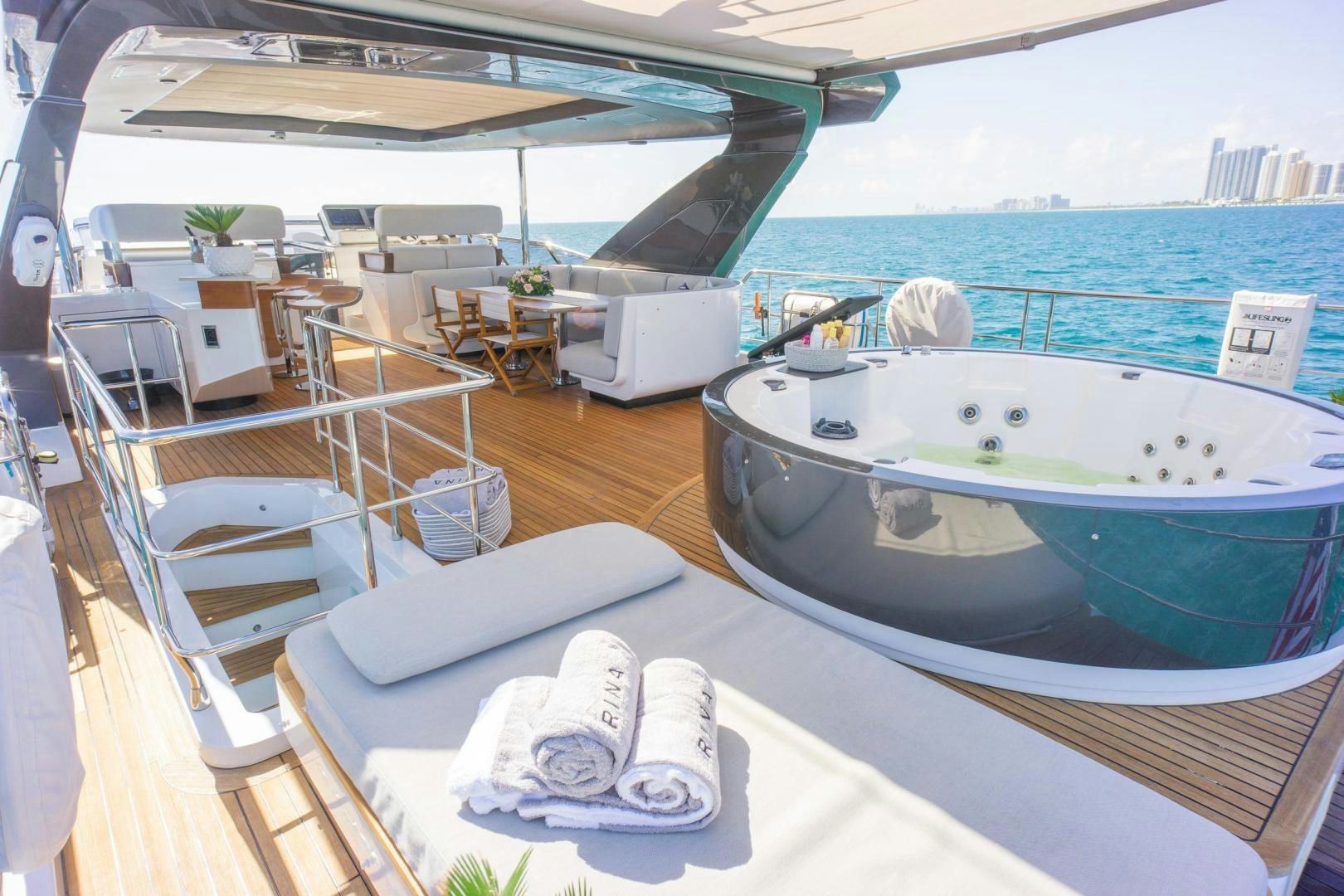 a person sitting on a lounge chair on a deck overlooking a large body of water aboard RINA Yacht for Sale