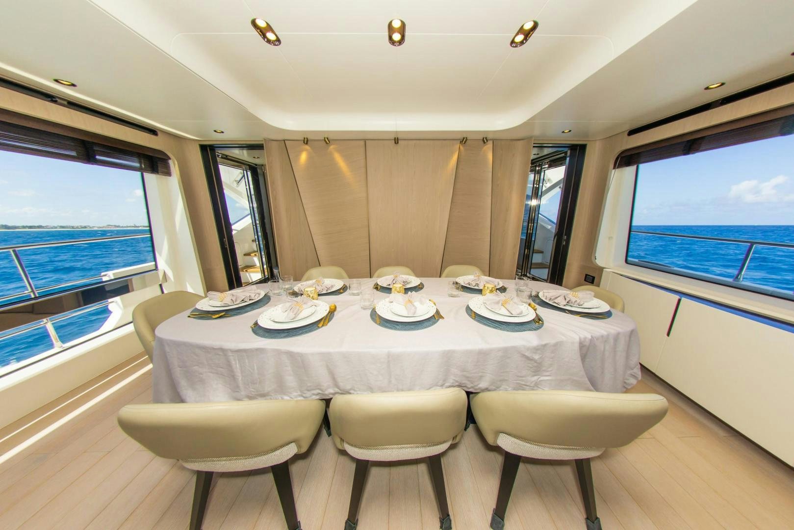 a dining table with plates and chairs aboard RINA Yacht for Sale