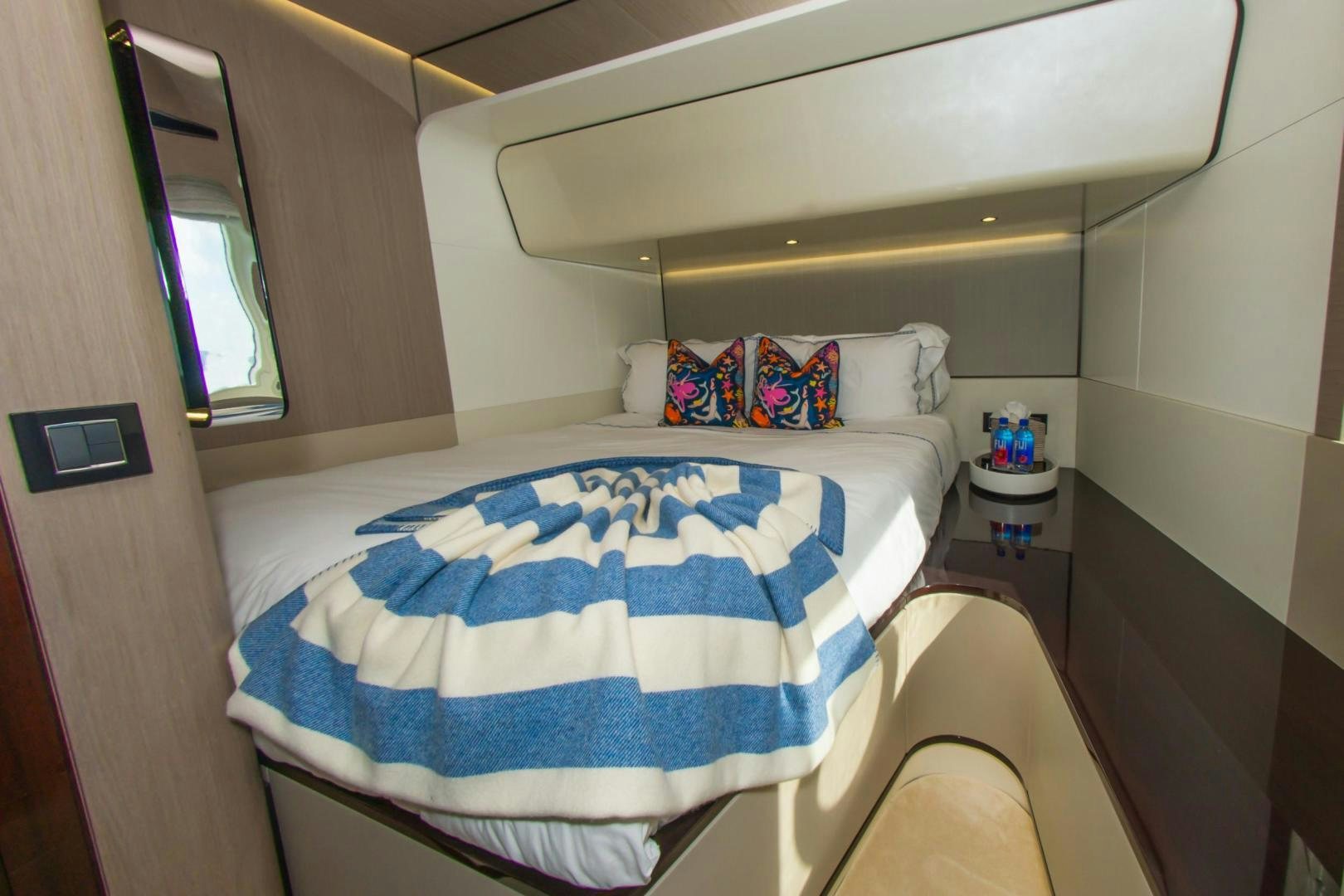 a bed with blue and white sheets aboard RINA Yacht for Sale