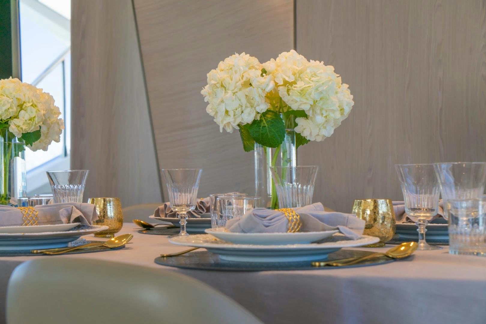 a table with plates and glasses aboard RINA Yacht for Sale