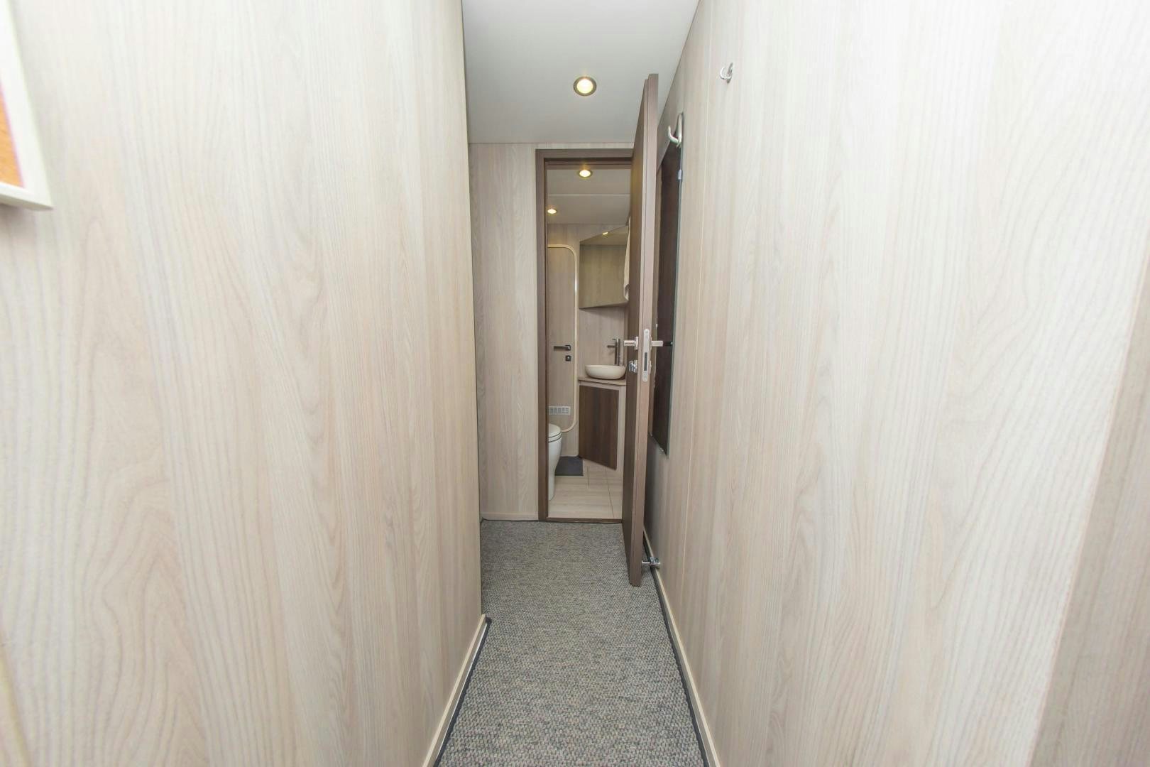 a hallway with a door and a mirror aboard RINA Yacht for Sale
