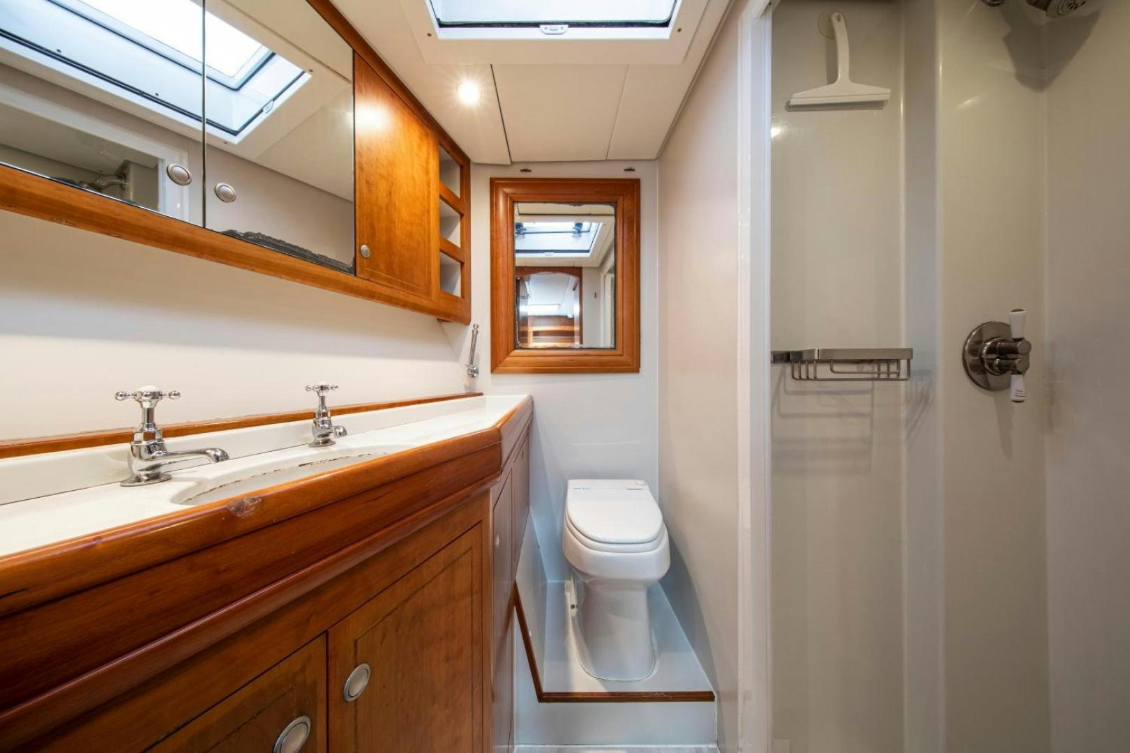 a bathroom with a sink toilet and a mirror aboard WAVELENGTH Yacht for Sale