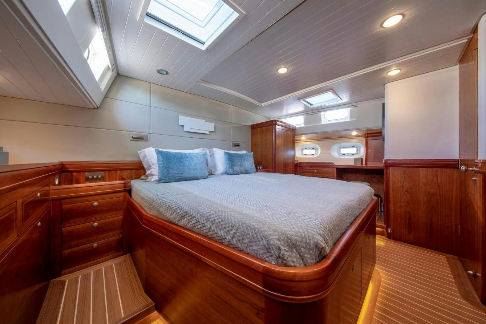 a bedroom with a bed and a dresser aboard WAVELENGTH Yacht for Sale