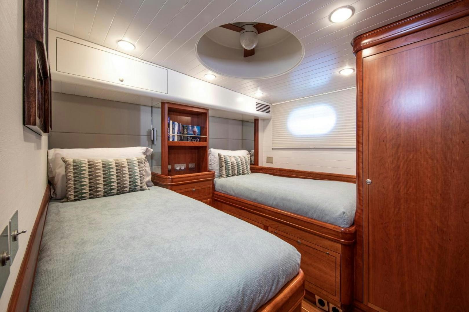 a bedroom with a bed and a bookcase aboard WAVELENGTH Yacht for Sale