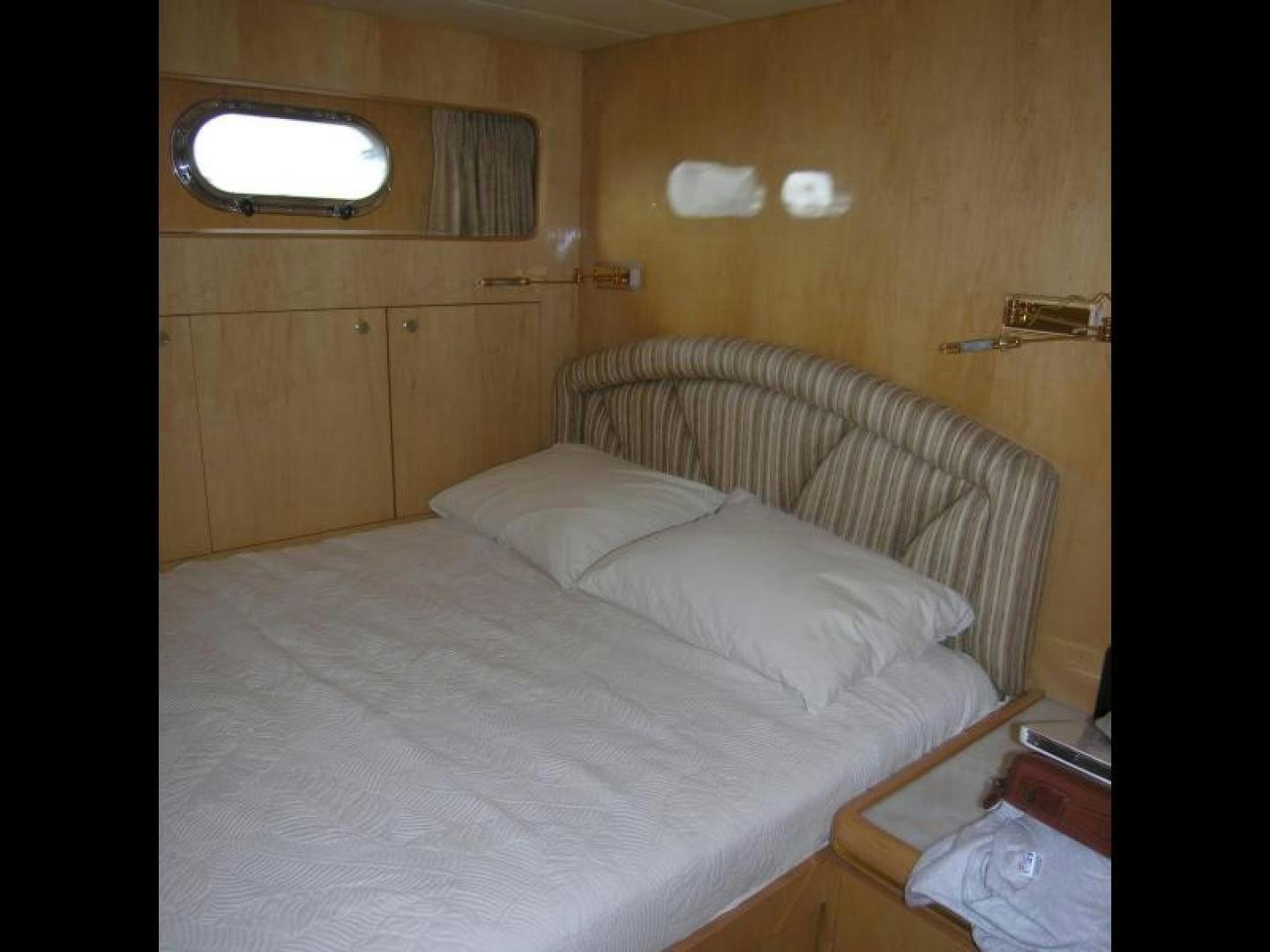 a bed with white sheets aboard BALOZI Yacht for Sale