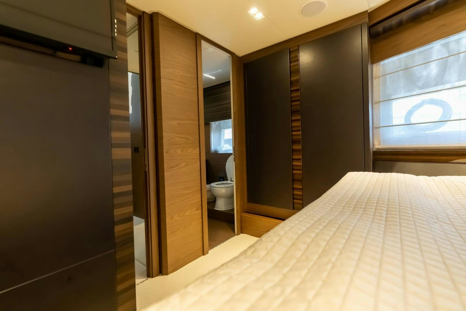 a bedroom with a bed and a closet aboard LEGEND Yacht for Sale