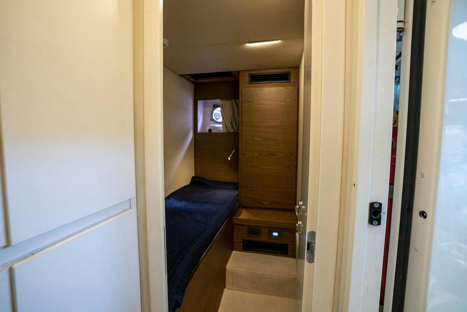 a hallway with a door and a television on the wall aboard LEGEND Yacht for Sale