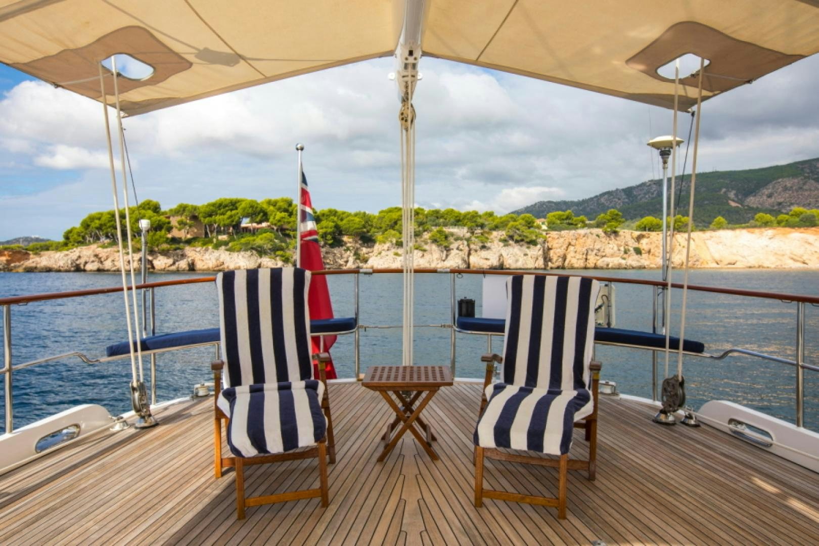 a deck with chairs and a boat on it aboard FIDELITAS Yacht for Sale