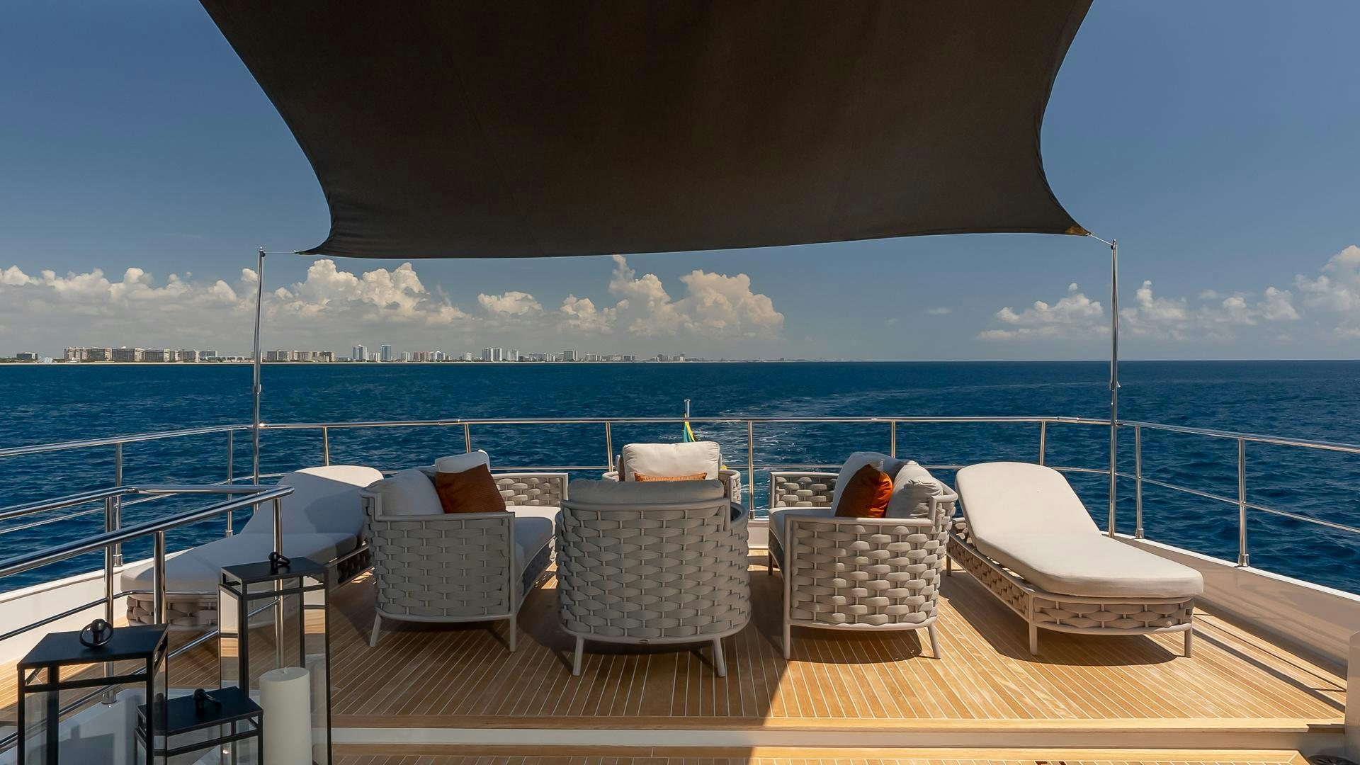a deck with chairs and a body of water in the background aboard BAD ROMANCE IV Yacht for Sale