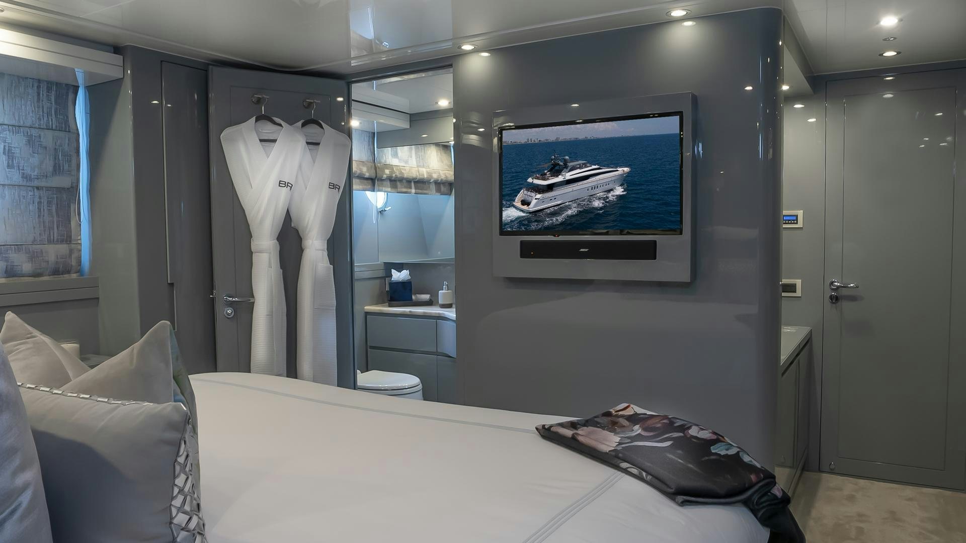 a room with a bed and a tv on the wall aboard BAD ROMANCE IV Yacht for Sale