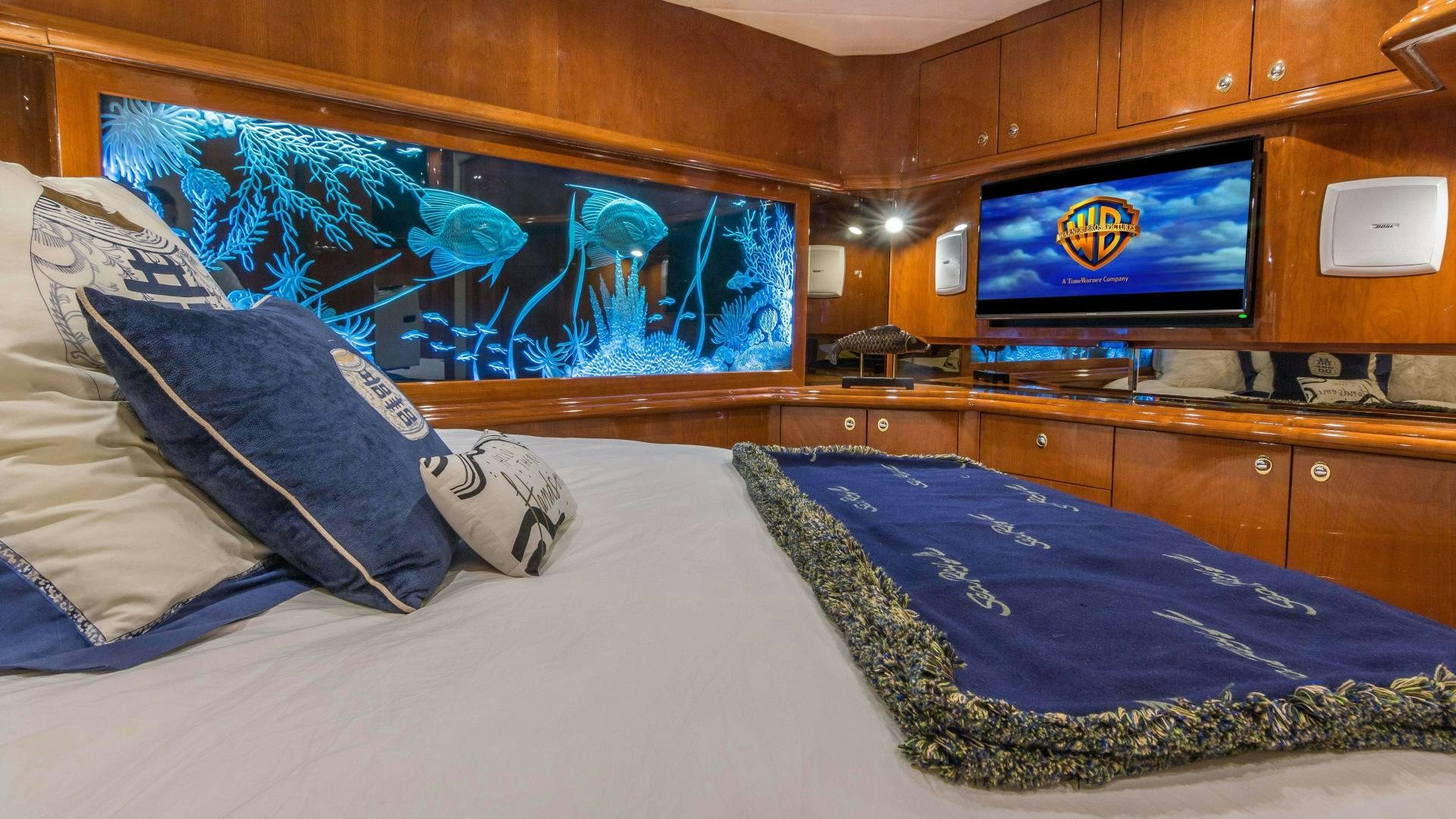 a bed with a blue blanket aboard XANADU Yacht for Sale
