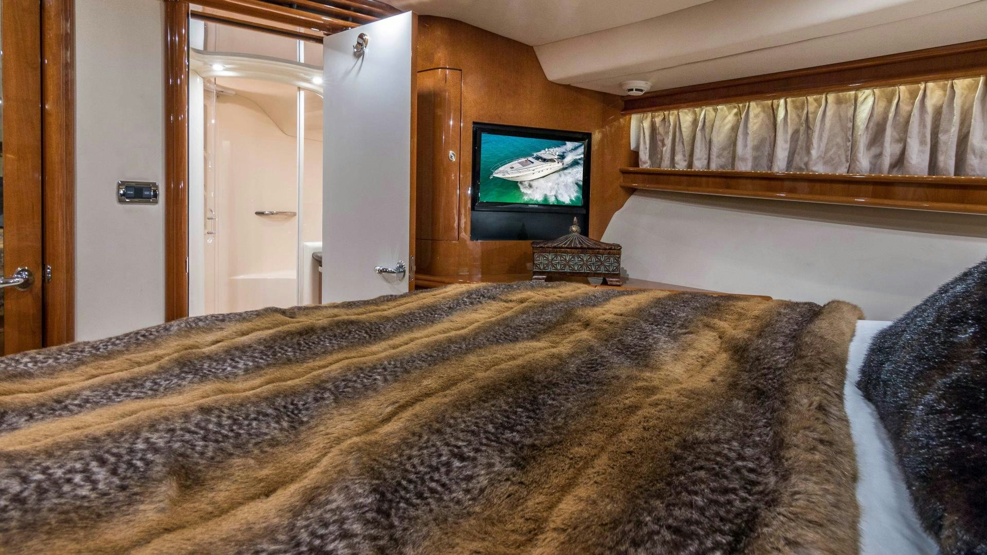 a large bed with a television on the wall aboard XANADU Yacht for Sale
