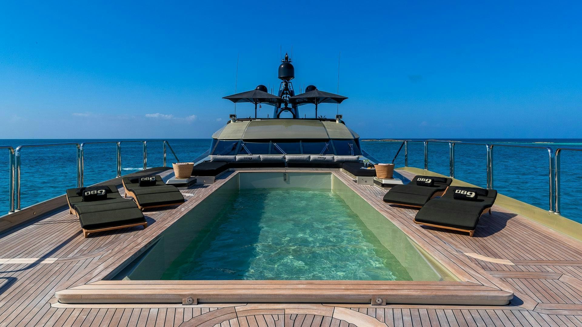 a pool with a large ship in the background aboard DB9 Yacht for Sale