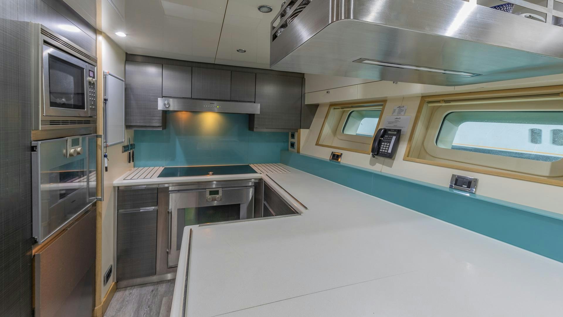 a kitchen with a microwave oven and cabinets aboard DB9 Yacht for Sale