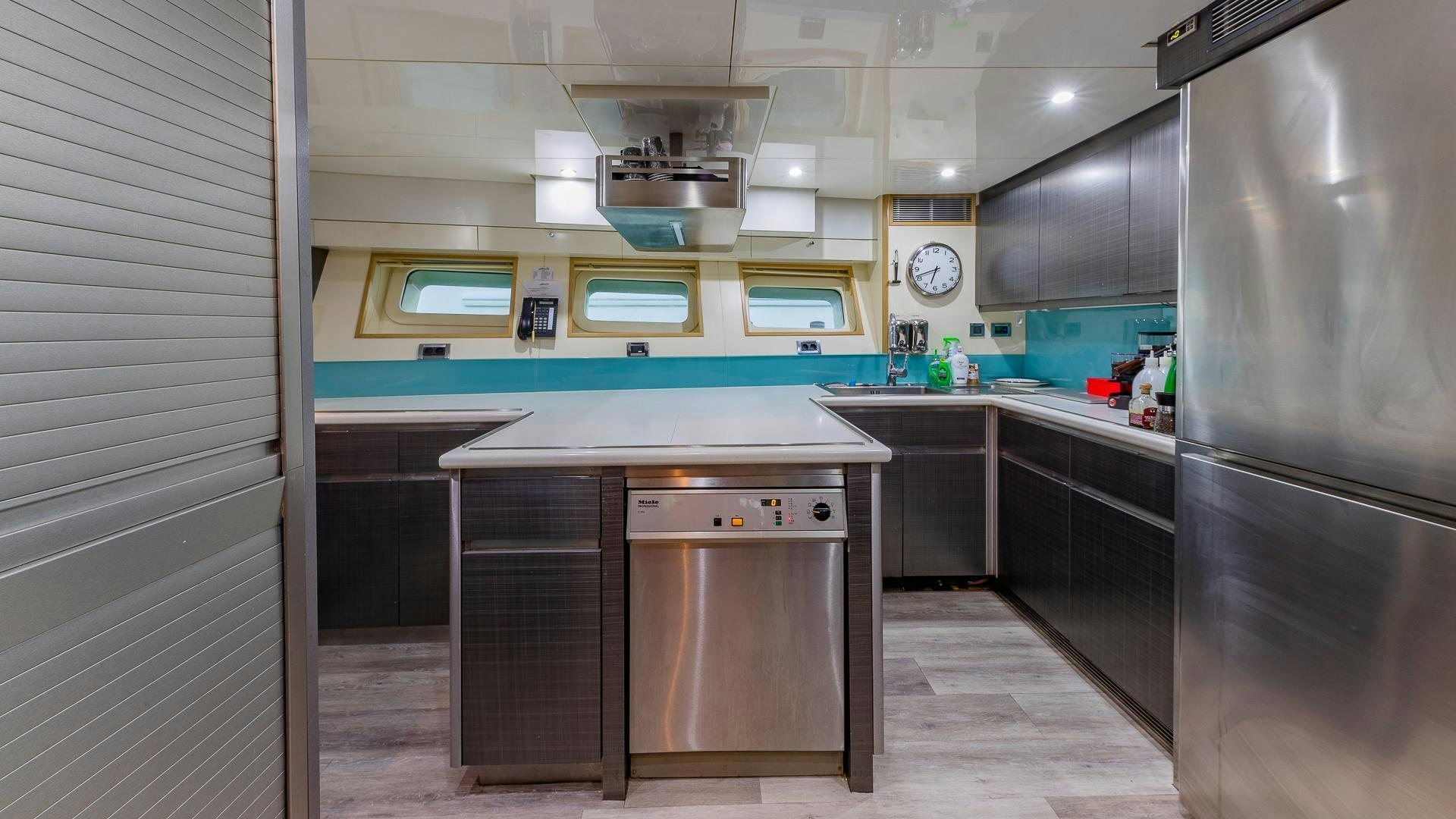 a kitchen with a stainless steel refrigerator aboard DB9 Yacht for Sale