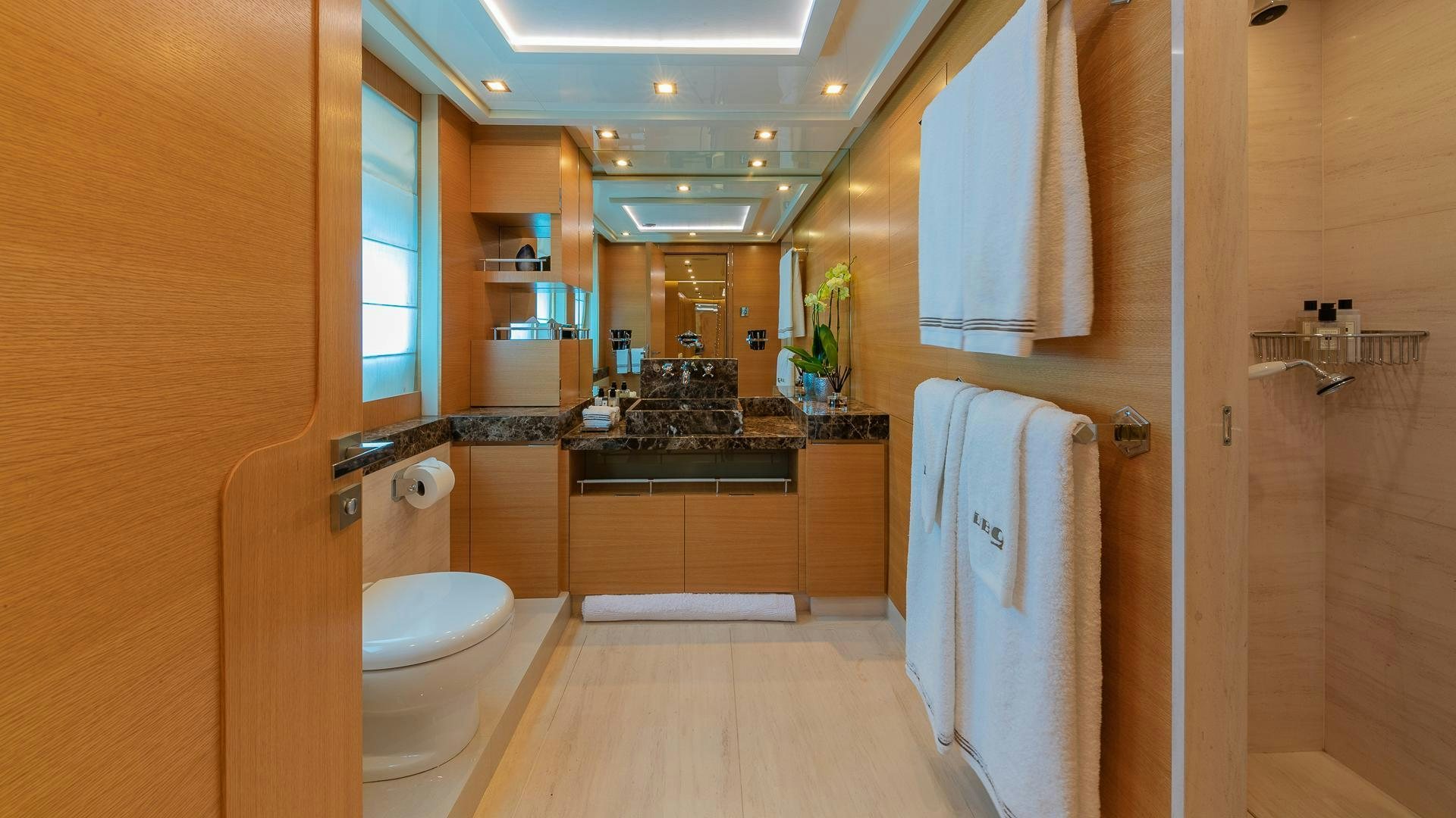 a bathroom with a sink toilet and towels aboard DB9 Yacht for Sale