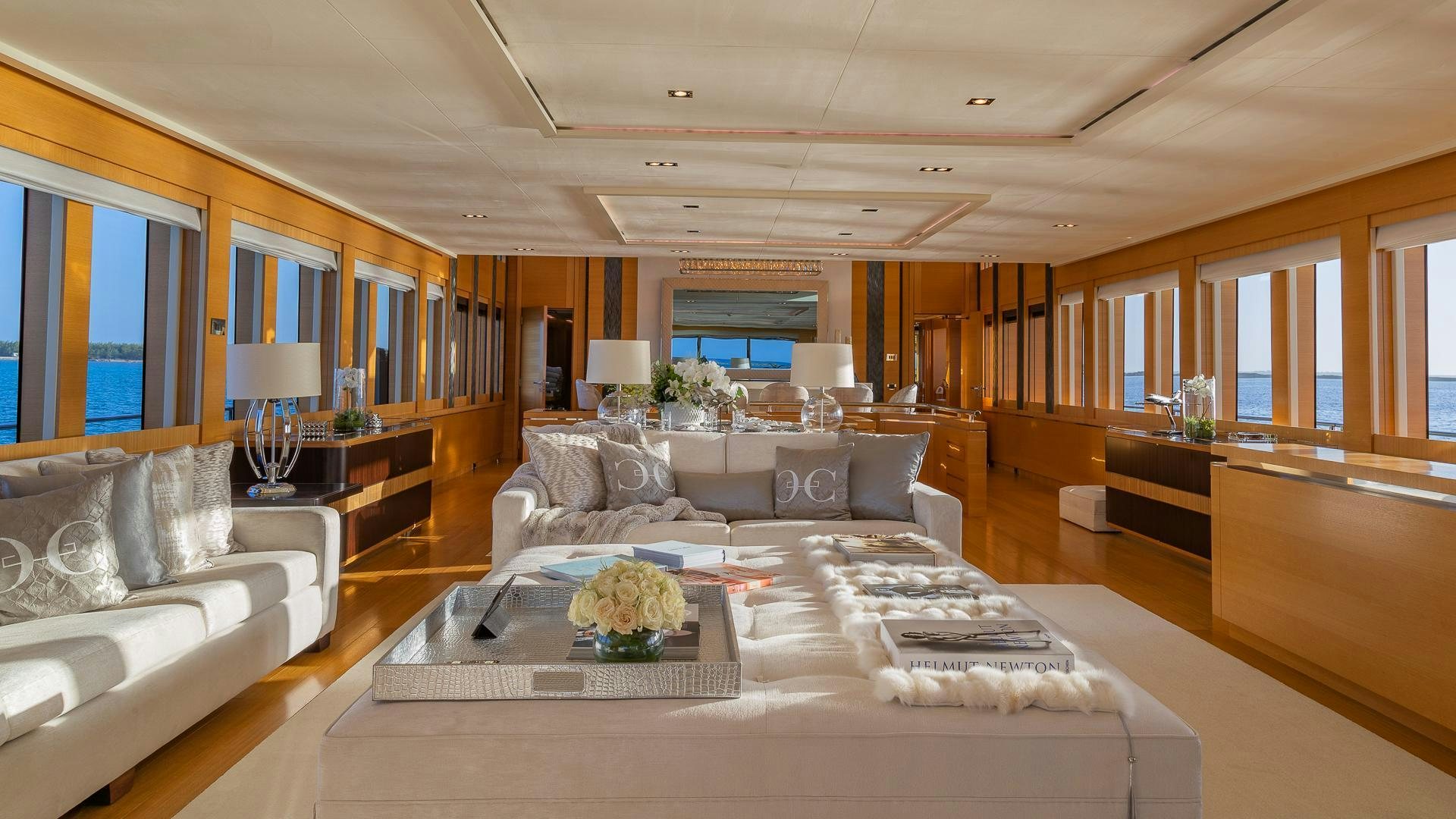 a living room with a large white couch and a large window aboard DB9 Yacht for Charter