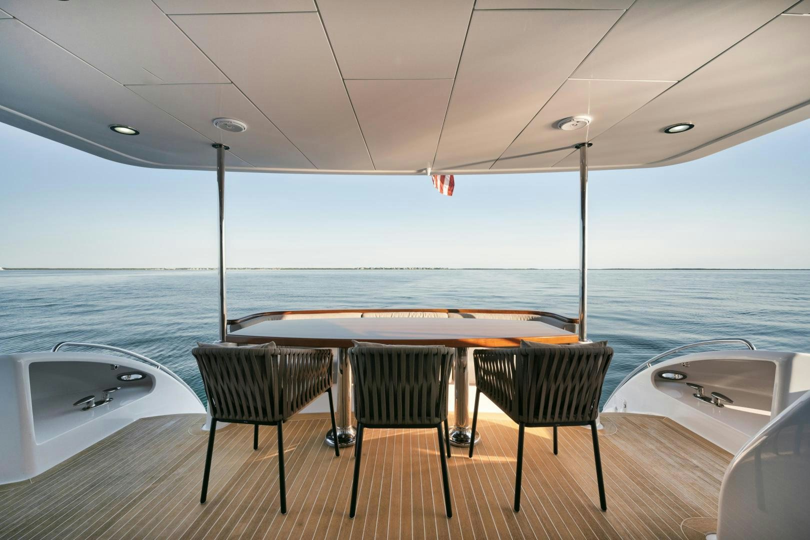 a table and chairs on a deck overlooking the ocean aboard EMMY Yacht for Sale