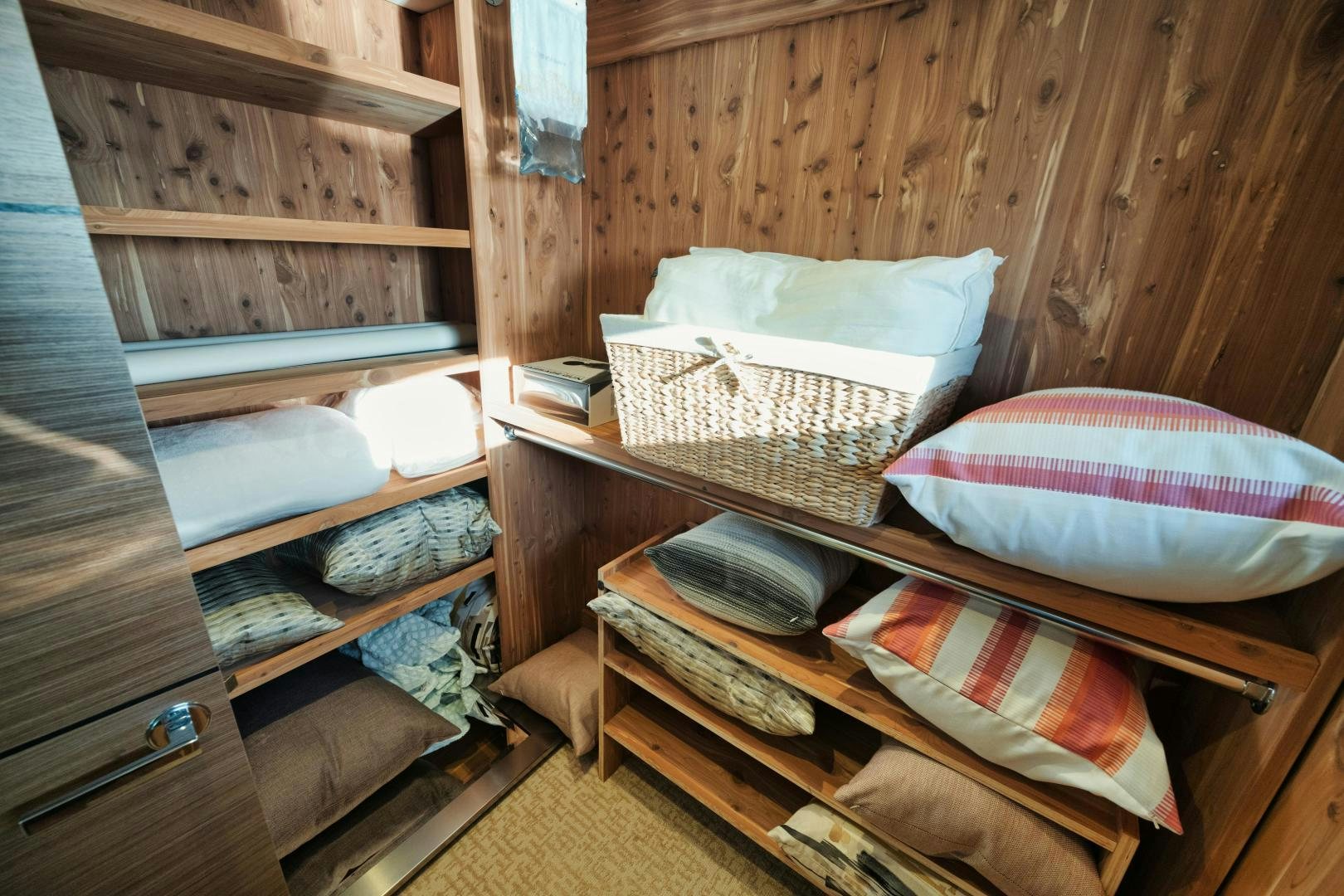 a wooden bunk bed with a basket and a stack of books aboard EMMY Yacht for Sale