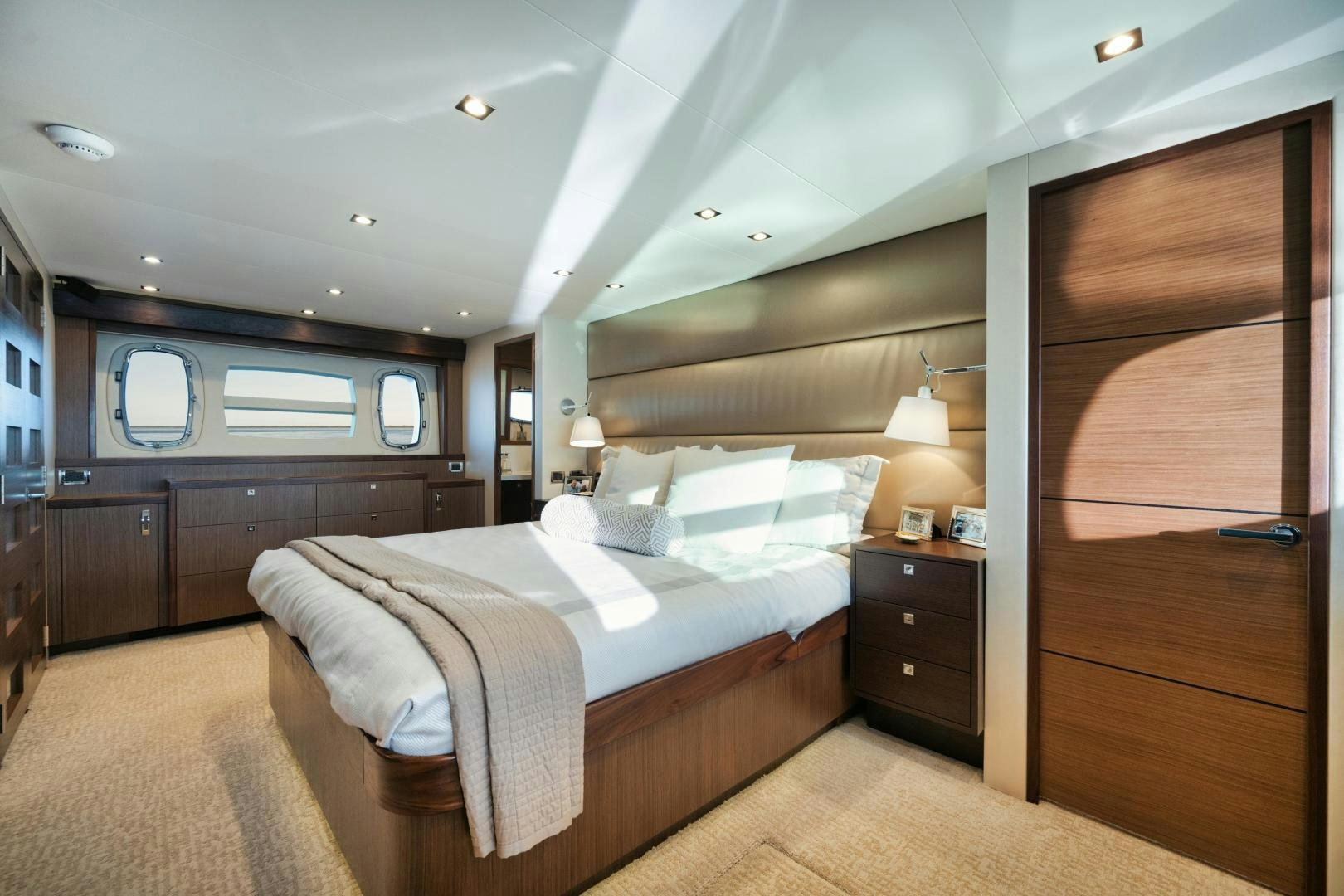 a bedroom with a bed and a wood door aboard EMMY Yacht for Sale