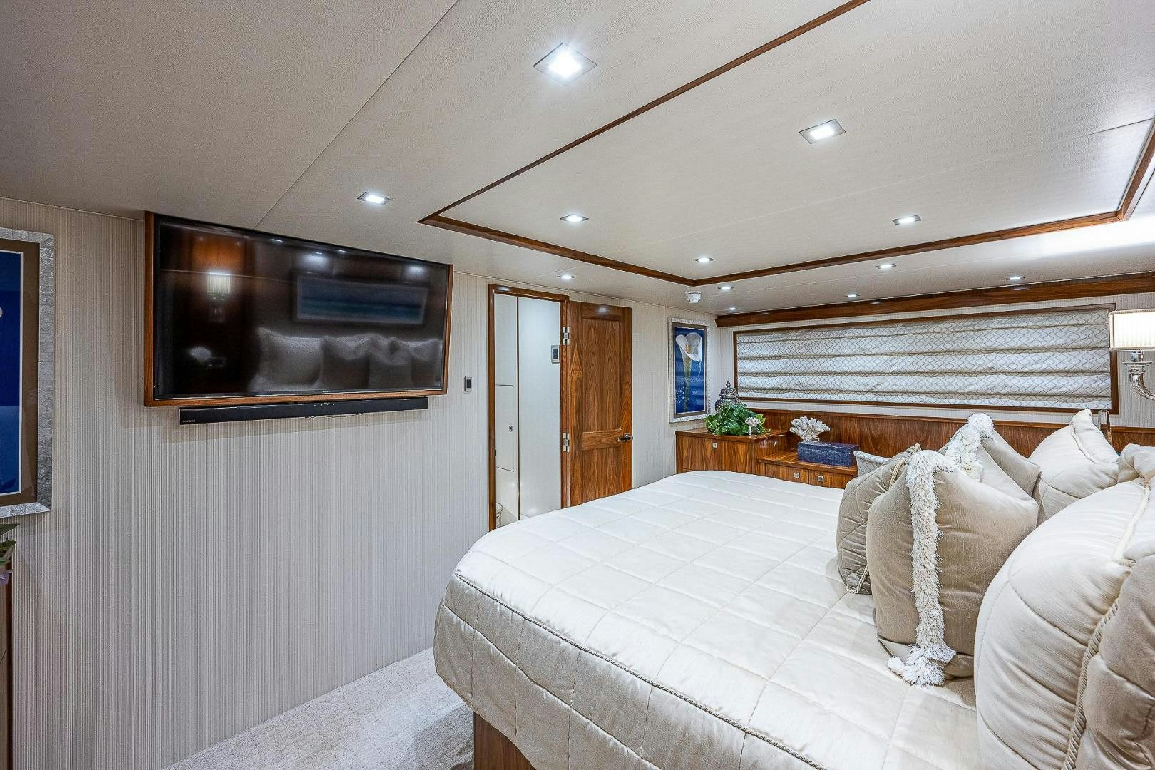 a bedroom with a bed and a tv on the wall aboard KALEEN Yacht for Sale