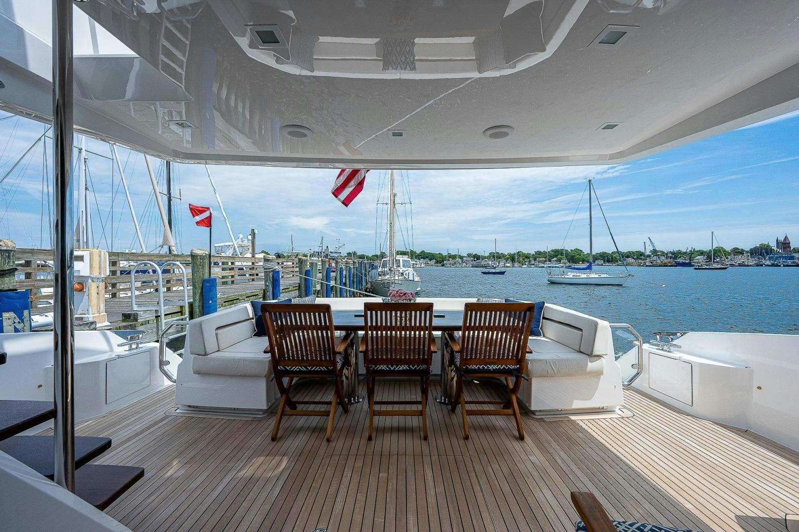 a deck with chairs and a table on it aboard KALEEN Yacht for Sale