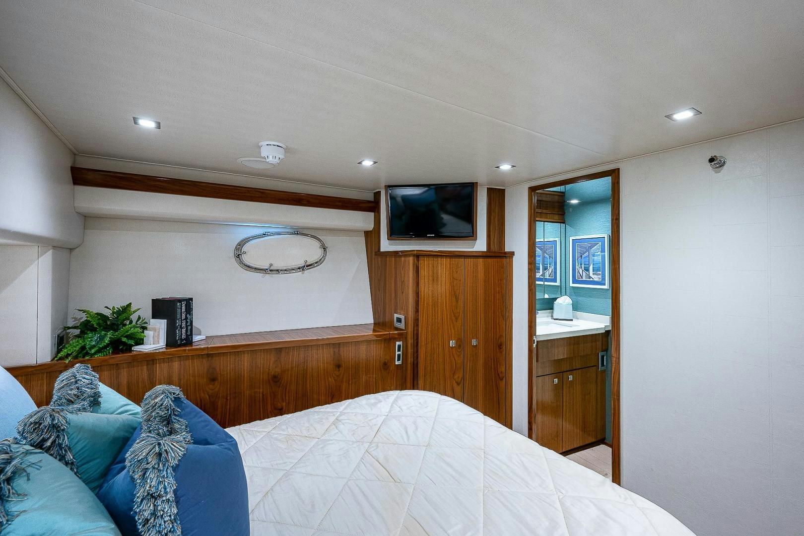 a bedroom with a bed and a television on the wall aboard KALEEN Yacht for Sale