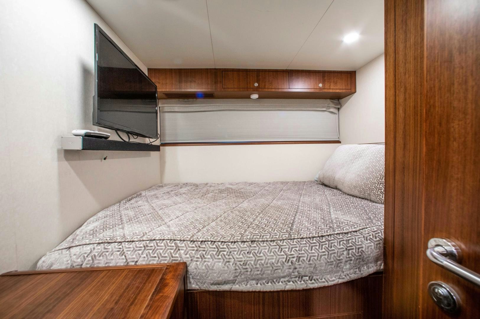 a bed with a television on the wall aboard TRINITY Yacht for Sale