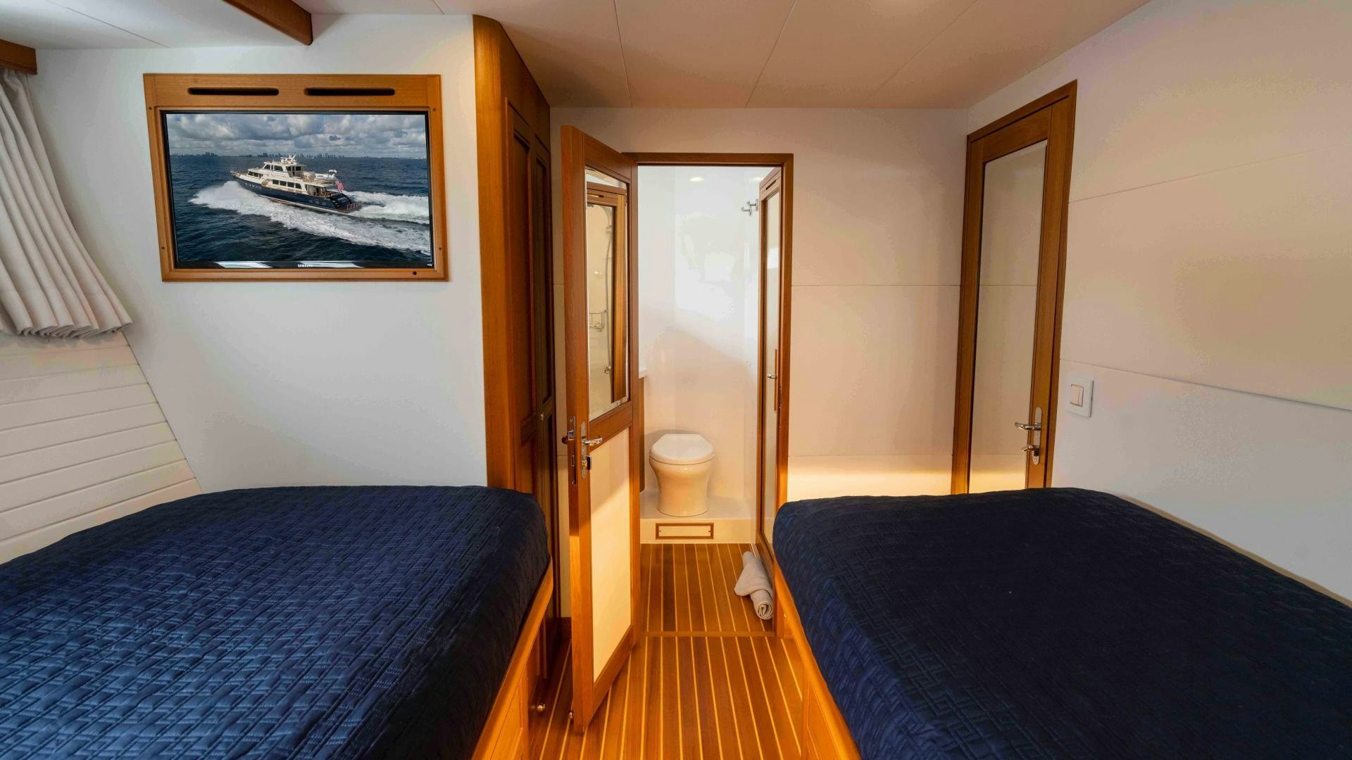 a bedroom with a bed and a painting on the wall aboard NEVER MY LOVE Yacht for Sale