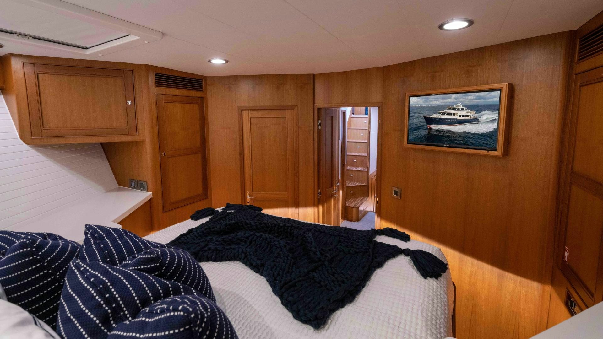 a bedroom with a bed and a wood wall aboard NEVER MY LOVE Yacht for Sale