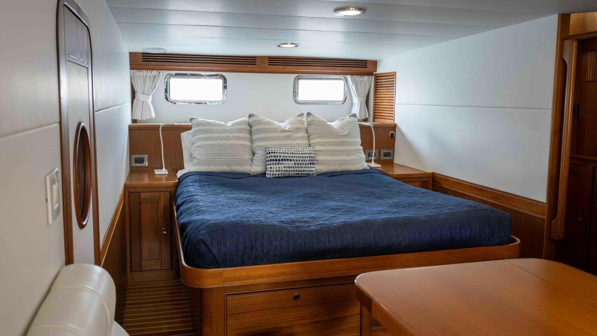a bed with a blue comforter aboard NEVER MY LOVE Yacht for Sale