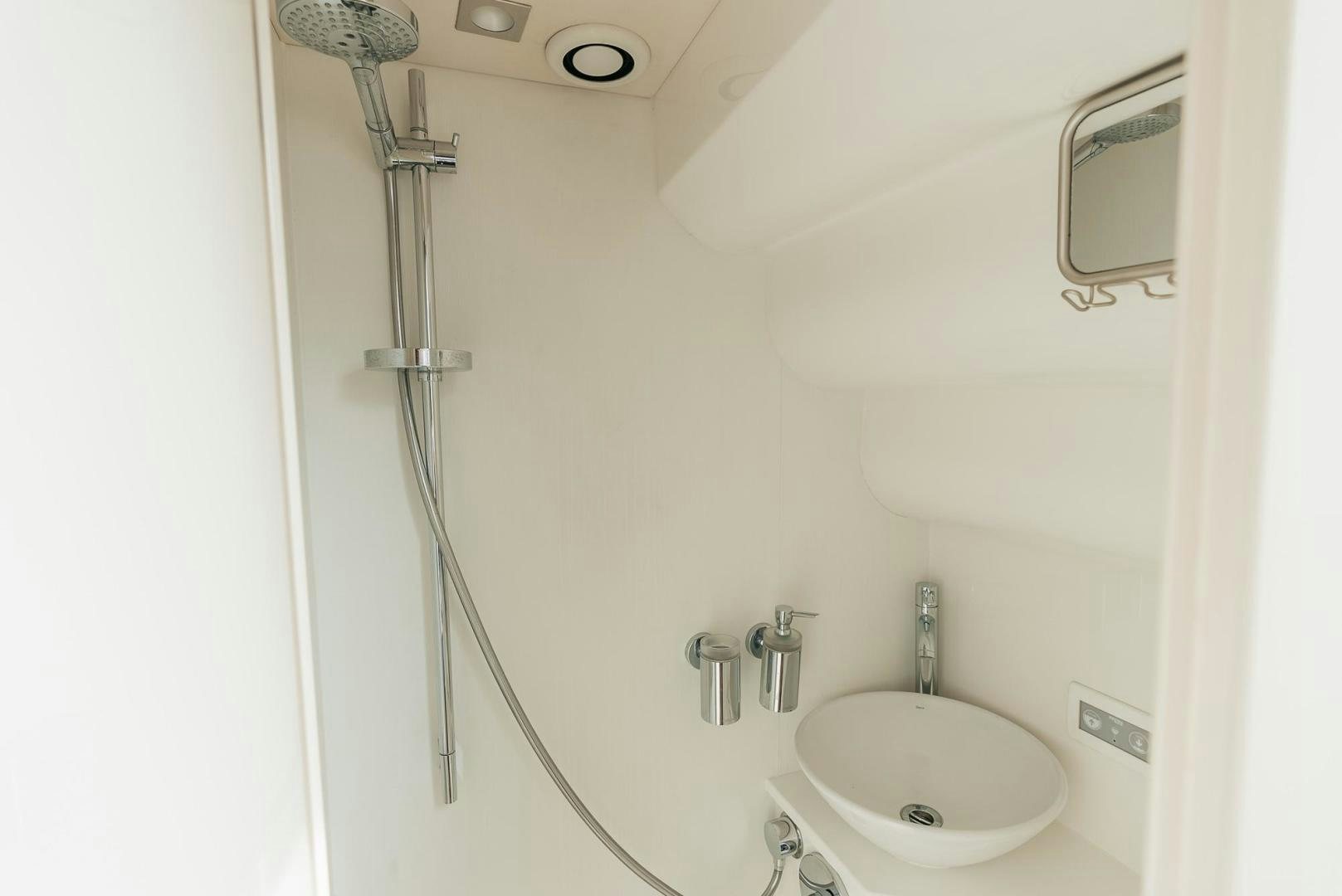 a shower with a sink and a mirror aboard GRAVITAS Yacht for Sale