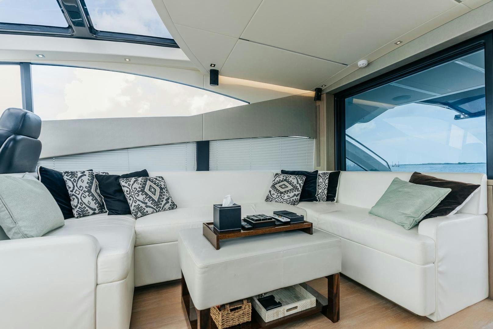 a white couch and a coffee table in a room with a large window aboard GRAVITAS Yacht for Sale
