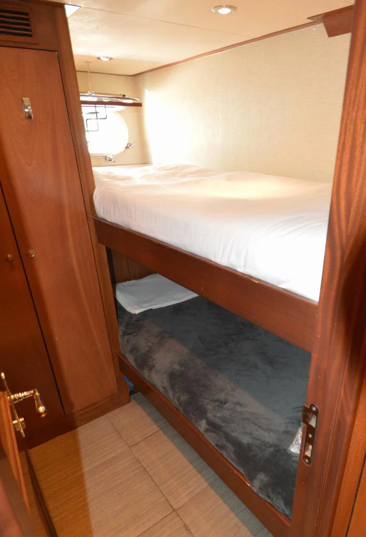 a bed with a wooden headboard aboard JOAN'S ARK Yacht for Sale
