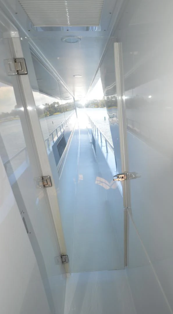 a hallway with glass doors aboard JOAN'S ARK Yacht for Sale