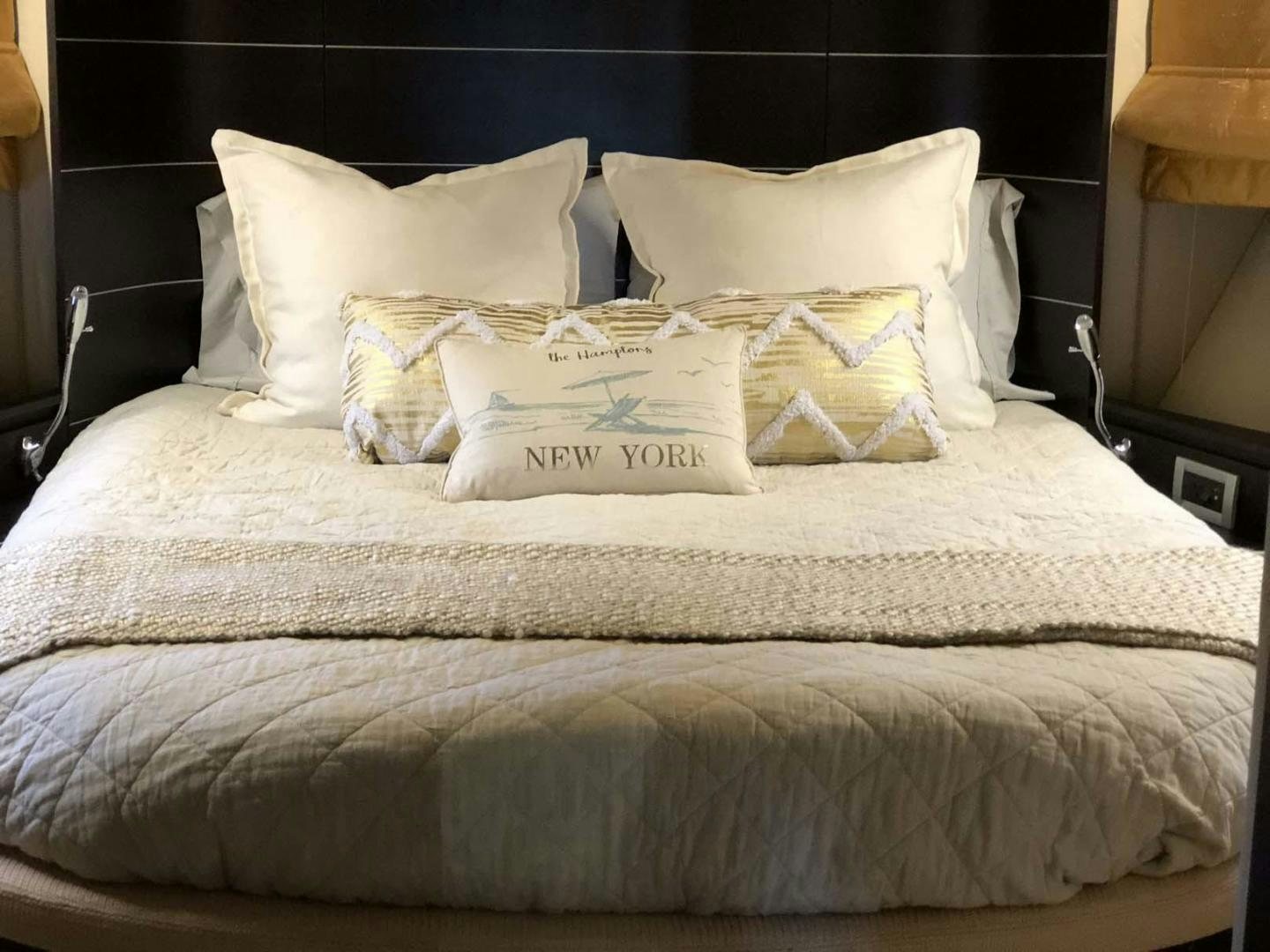 a bed with white sheets and pillows aboard ARTISTIC Yacht for Sale