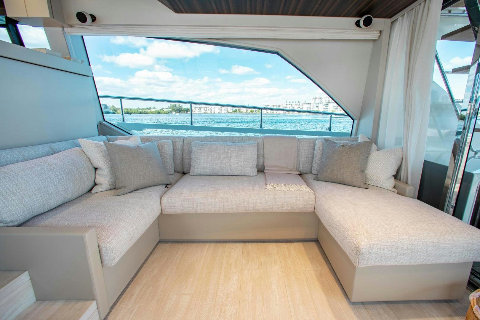 a couch and a window in a room aboard Ferretti 670 Yacht for Sale