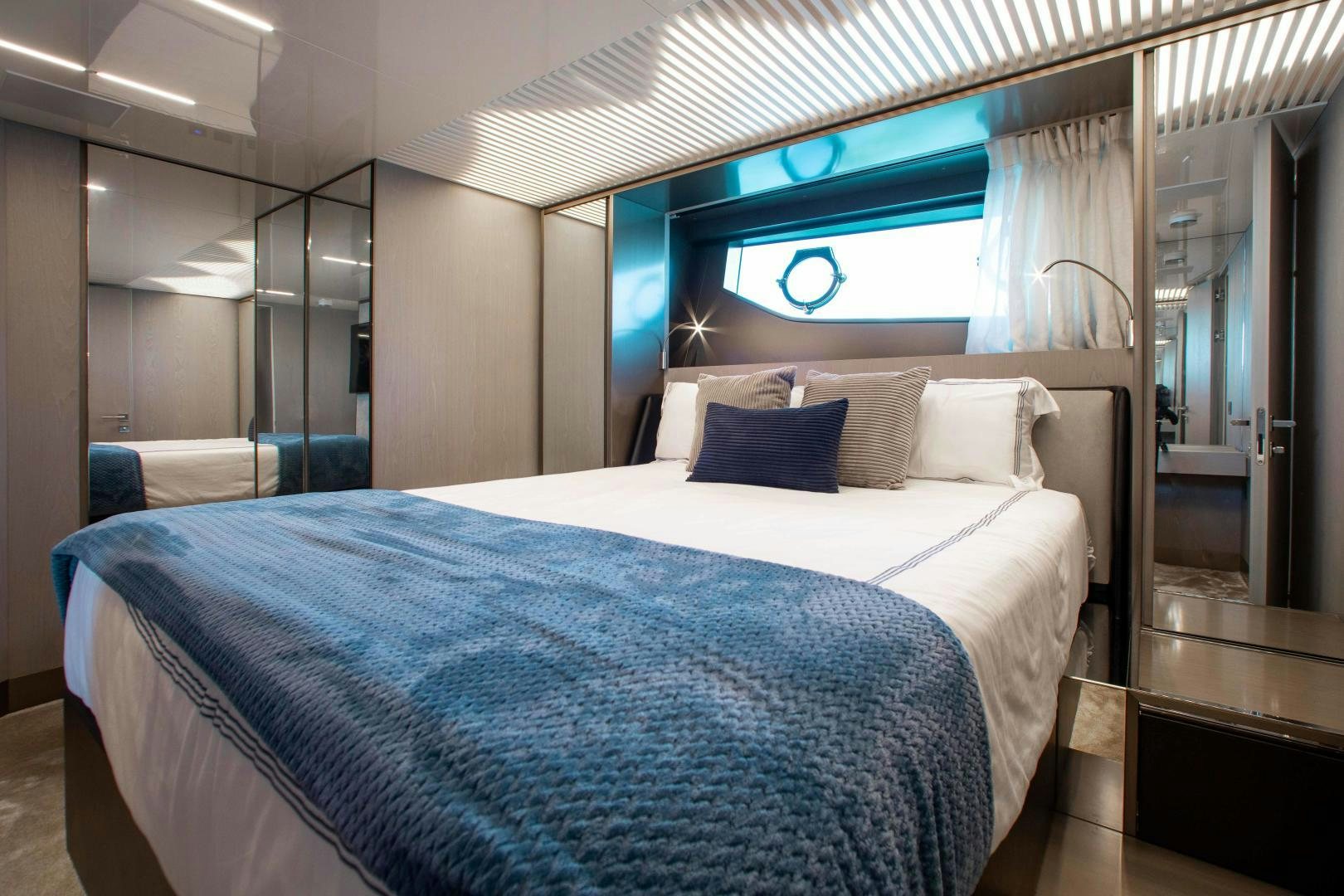 a bed with a blue and white bed spread aboard CRAZY Yacht for Sale