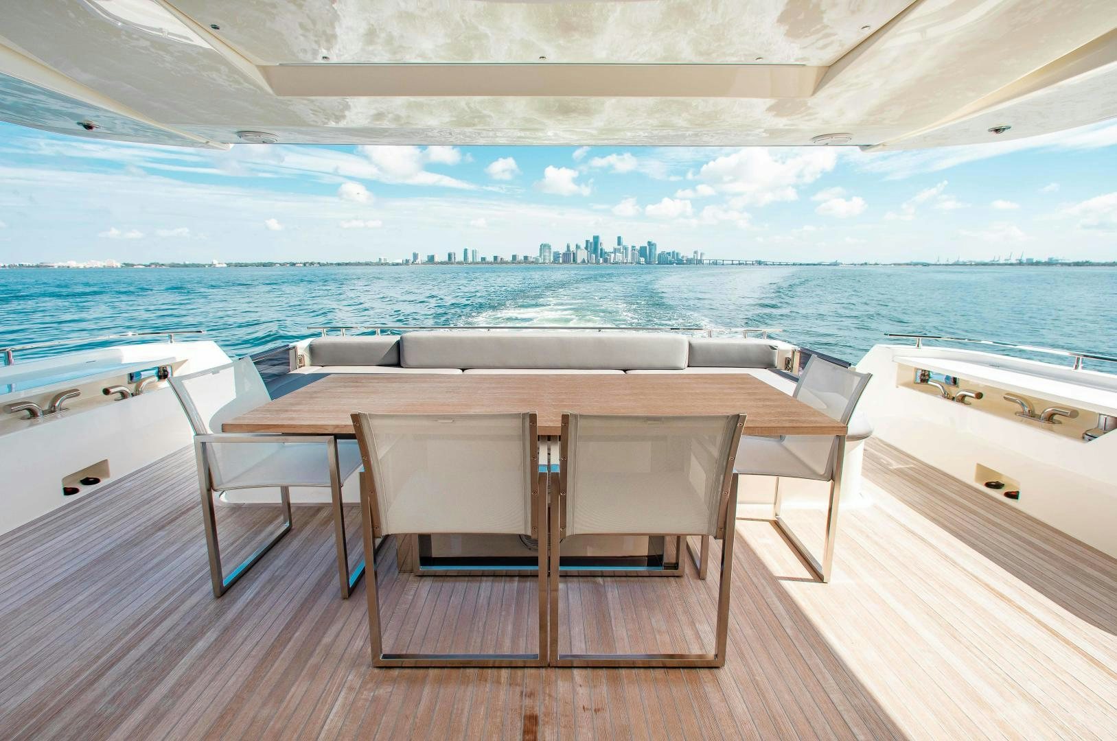 a table and chairs on a deck overlooking a body of water aboard CRAZY Yacht for Sale