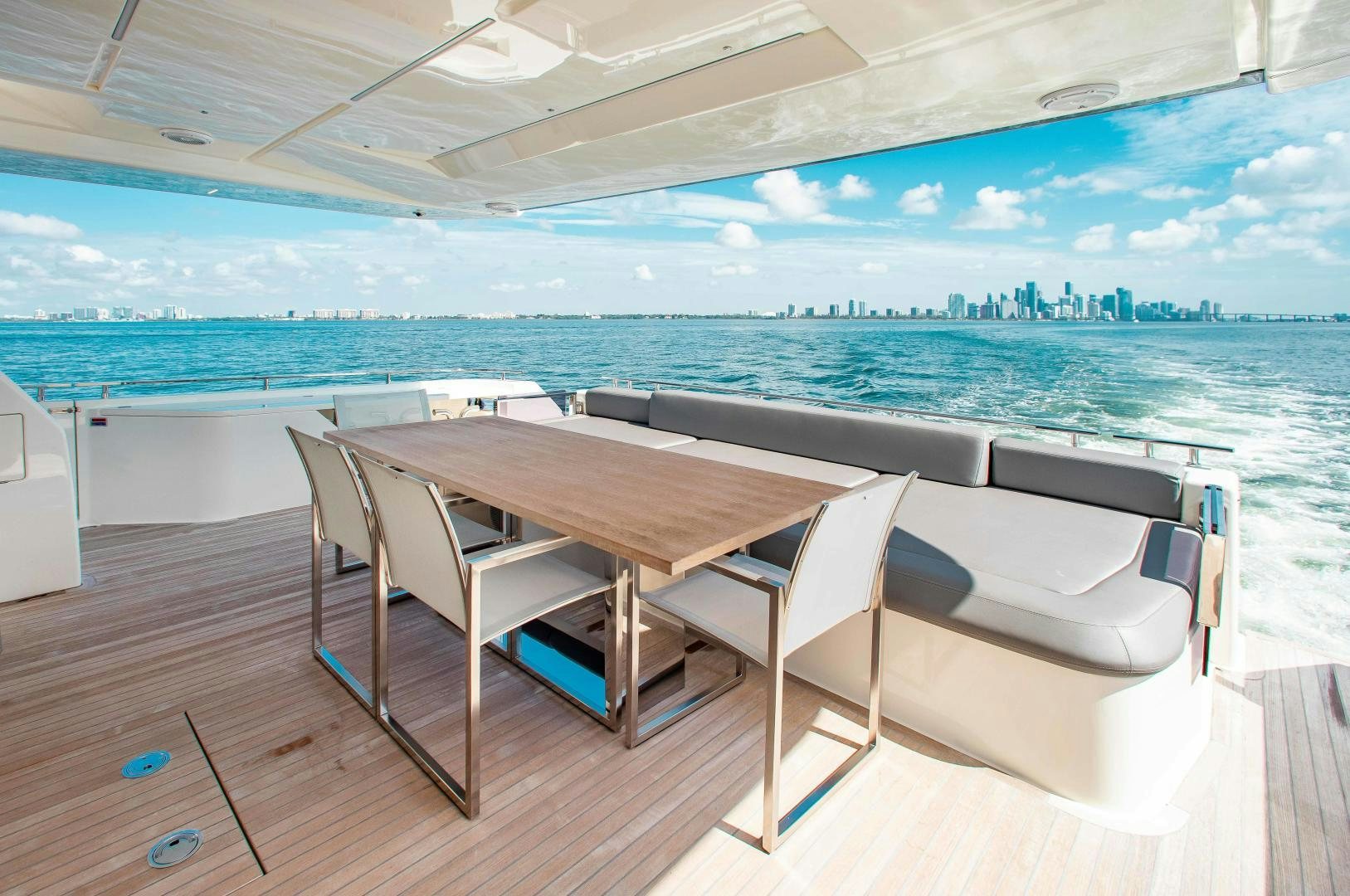 a table and chairs on a deck overlooking a body of water aboard CRAZY Yacht for Sale