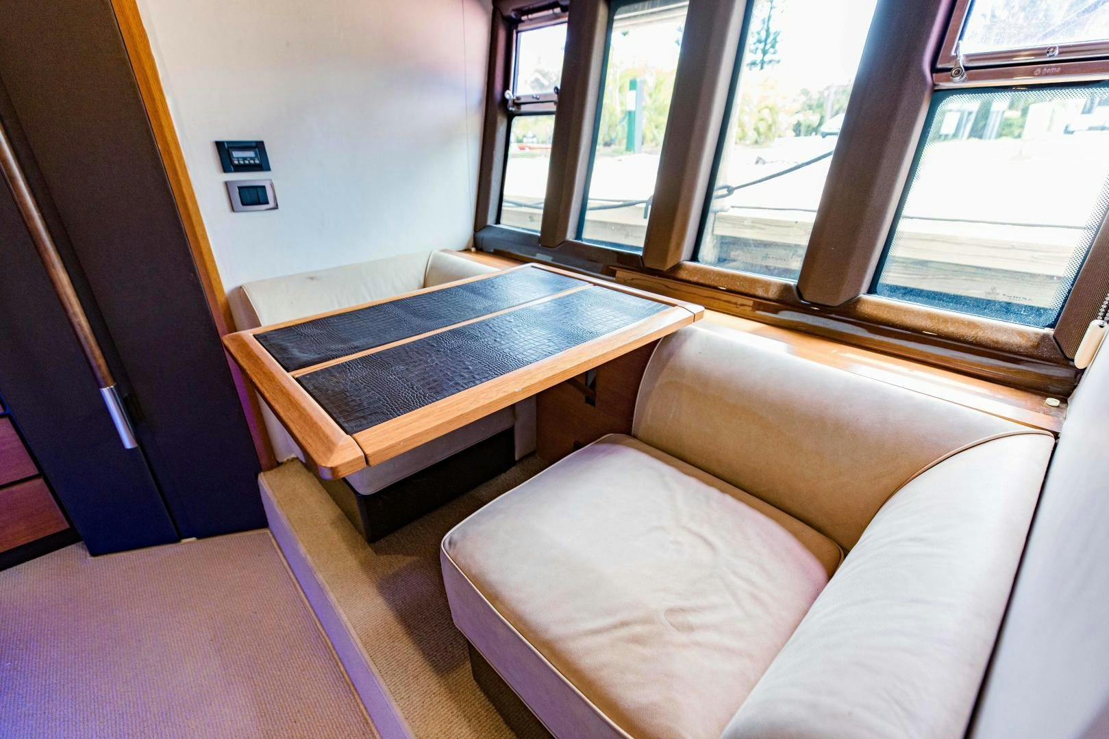 a couch and a coffee table in a room with windows aboard Azimut 70 Yacht for Sale